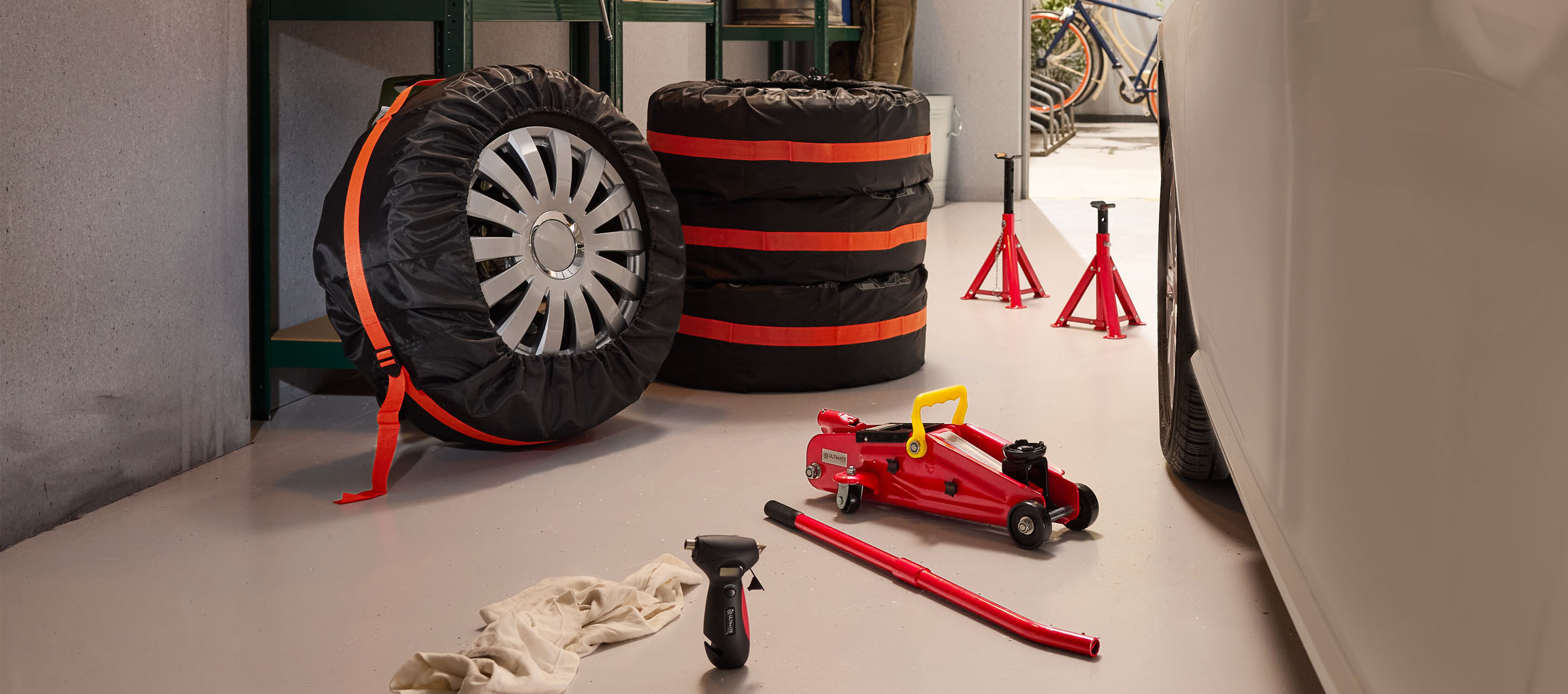 Autoreifen mit Hüllen, Wagenheber und Unterstellböcke in einer Garage.