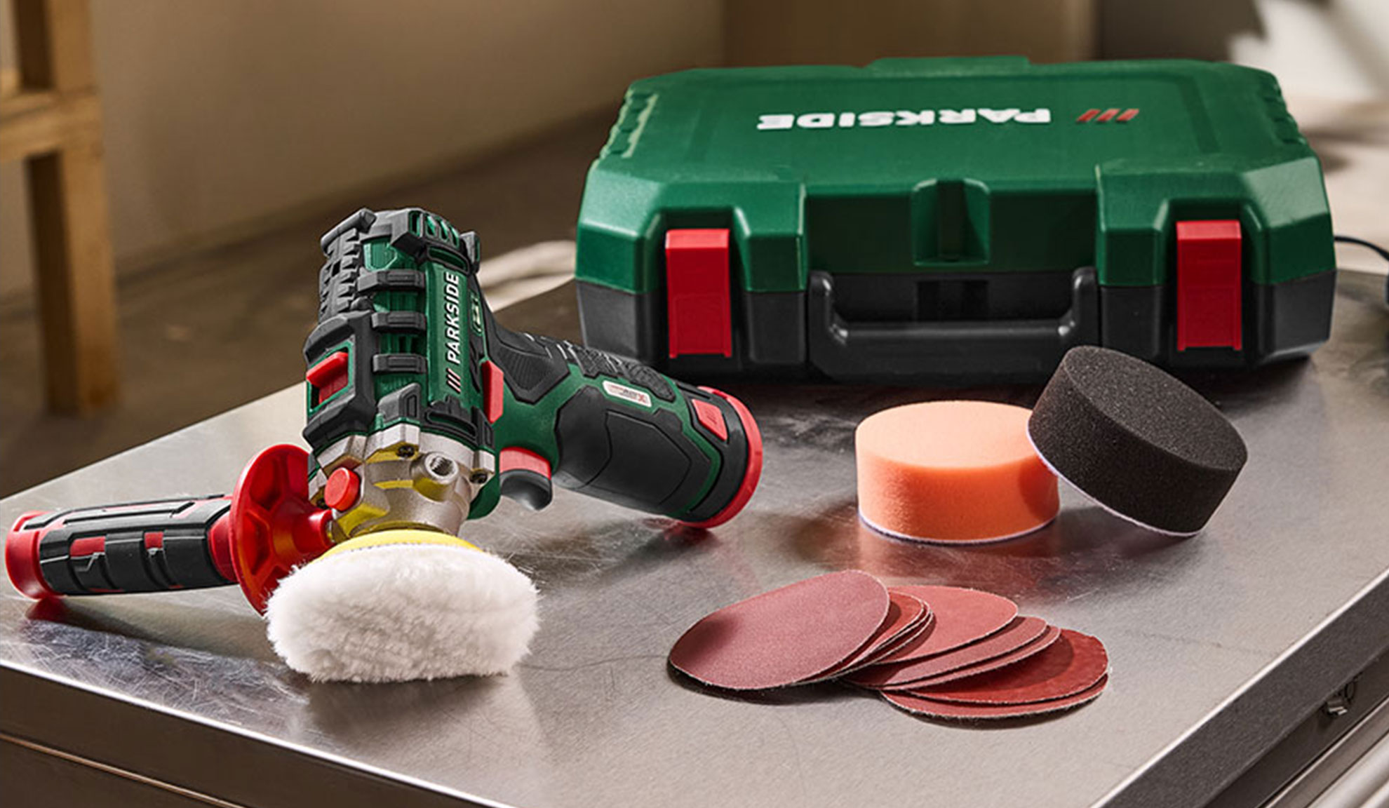 Lucidatrice a batteria con accessori, inclusi tamponi lucidanti e dischi abrasivi.
