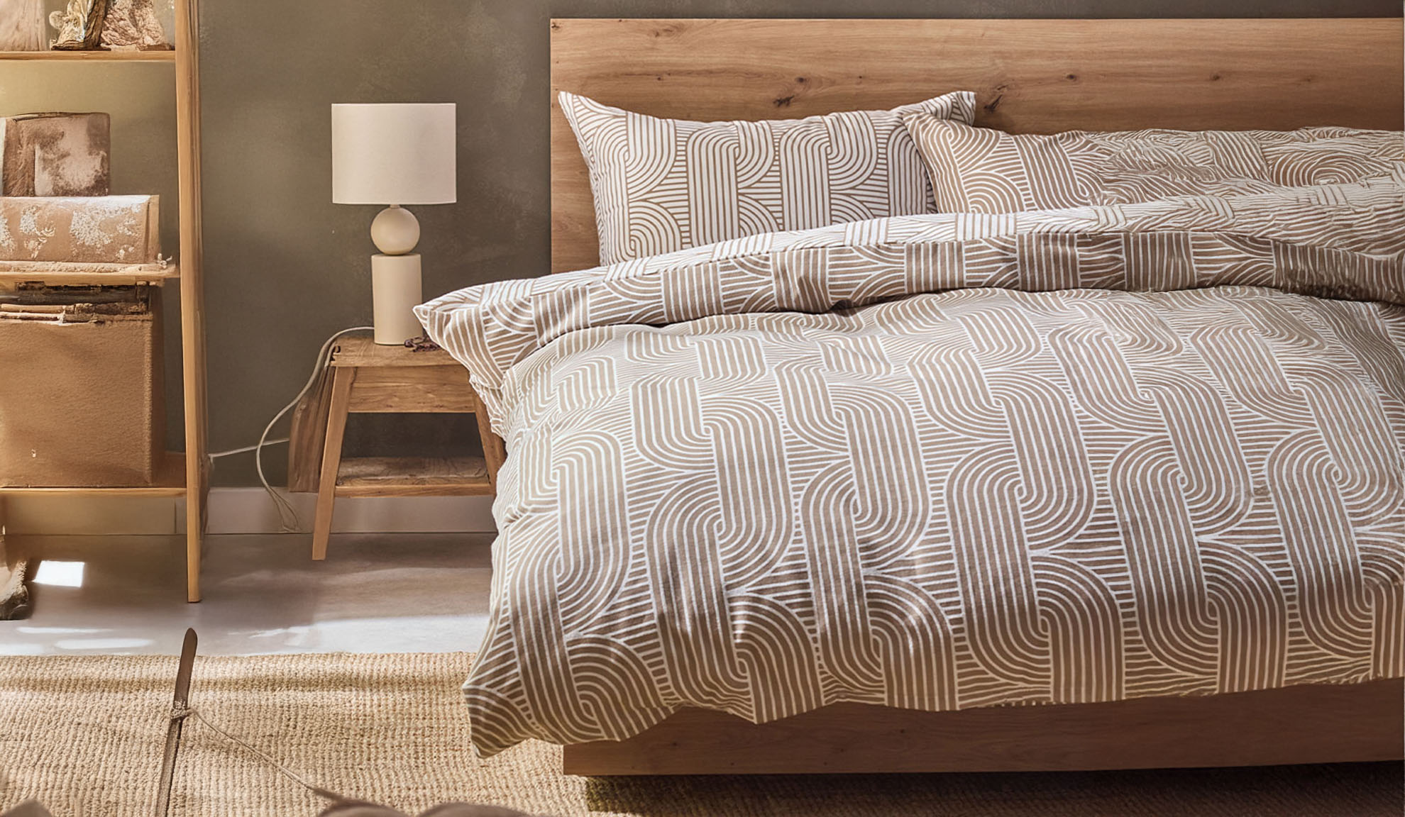Camera da letto con letto in legno, biancheria da letto con motivo geometrico e comodino con lampada.