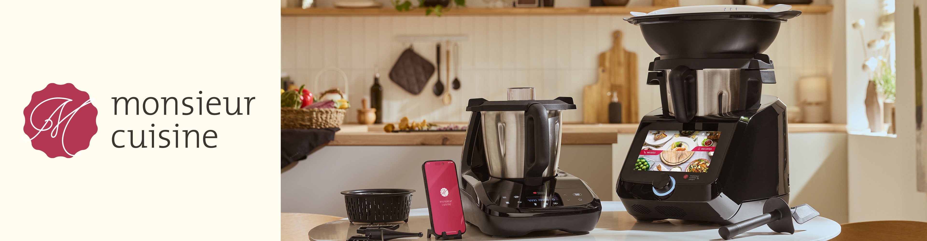 Zwei Monsieur Cuisine Küchenmaschinen auf einer Küchentheke mit einem Telefon und Zubehör.