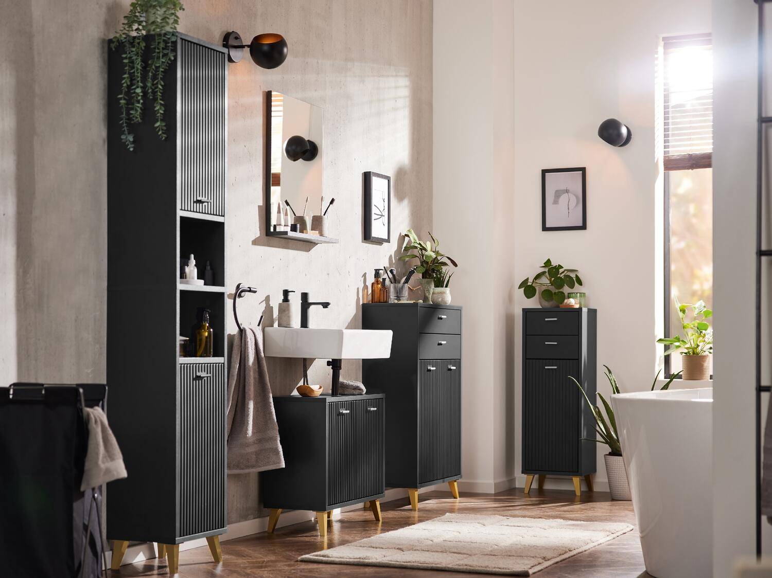 Ein modernes Badezimmer mit gerippten schwarzen Möbeln, weißem Waschbecken und grünen Pflanzen.