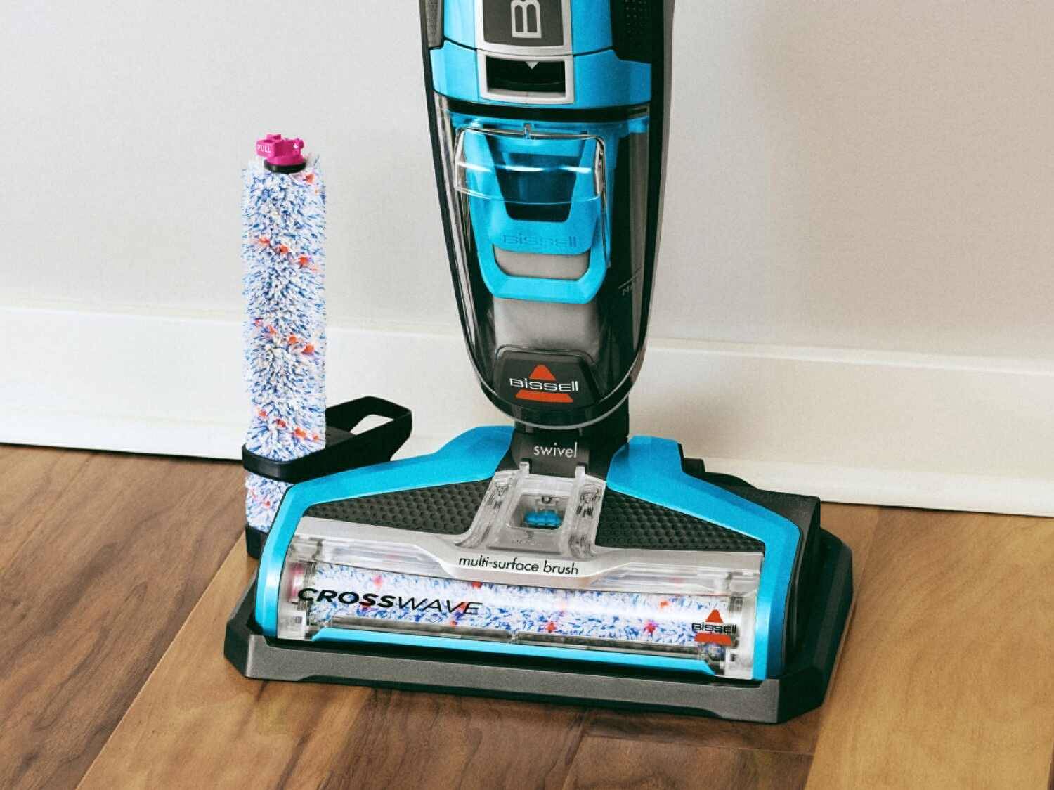 Blauer und schwarzer Bissell Crosswave Staubsauger mit Mehrflächenbürste und Ersatzrolle.