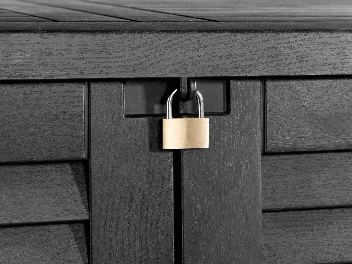 Lucchetto in ottone su una cassapanca da esterno nera testurizzata.