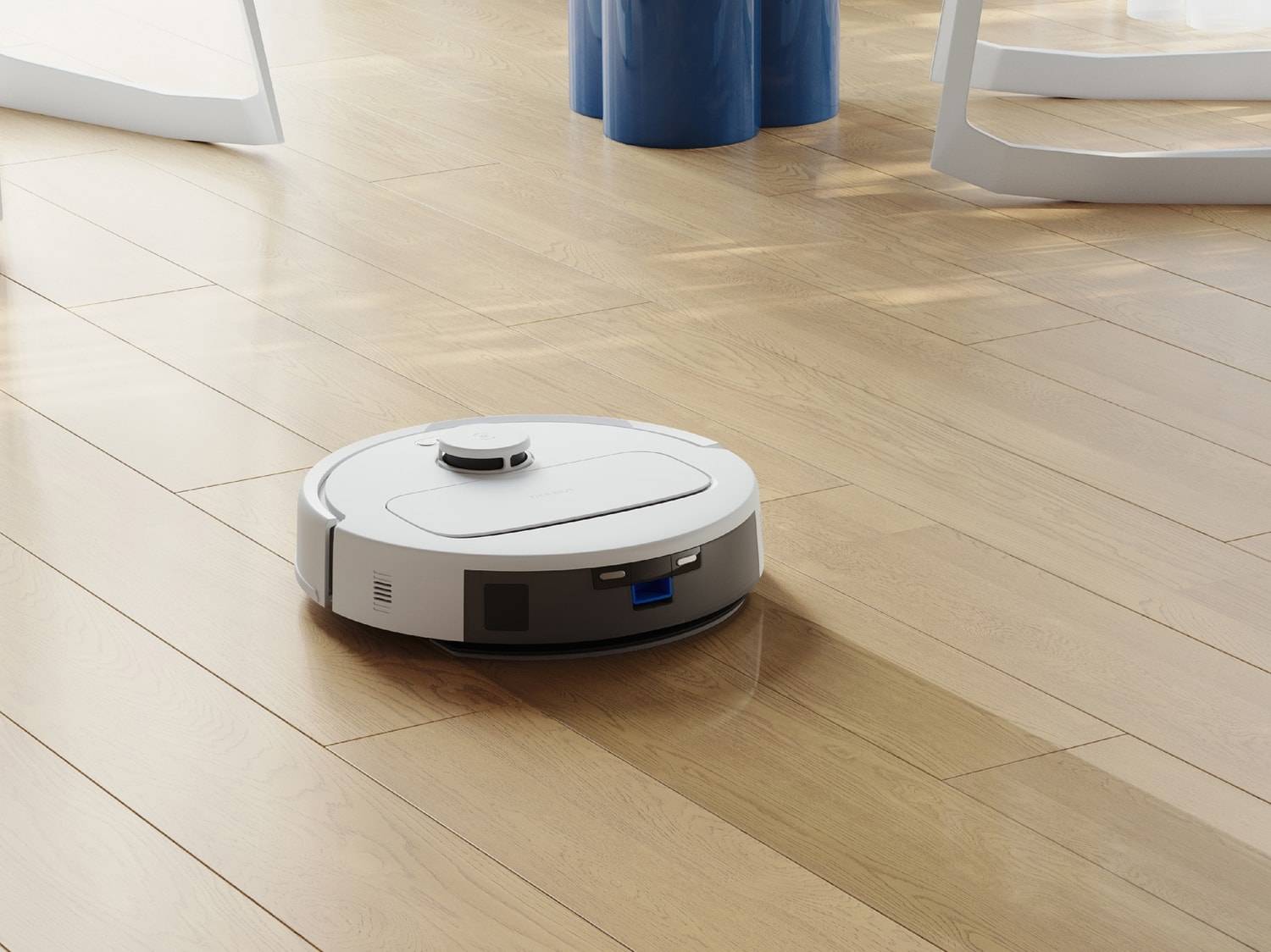 Un robot aspirateur blanc sur un parquet en bois, ayant nettoyé une partie du sol.