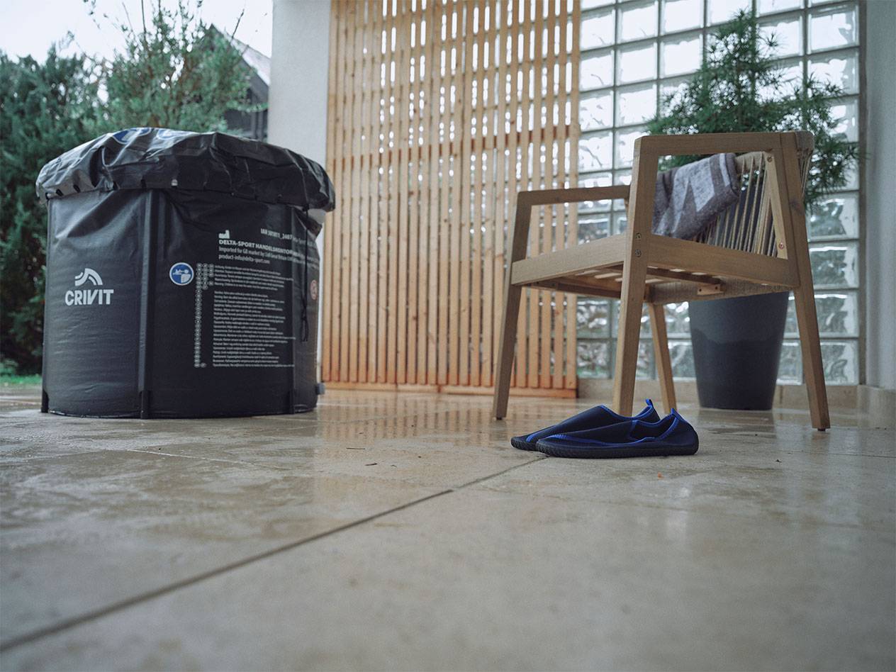 Piscina gonfiabile Crivit e scarpe da acqua su un patio.