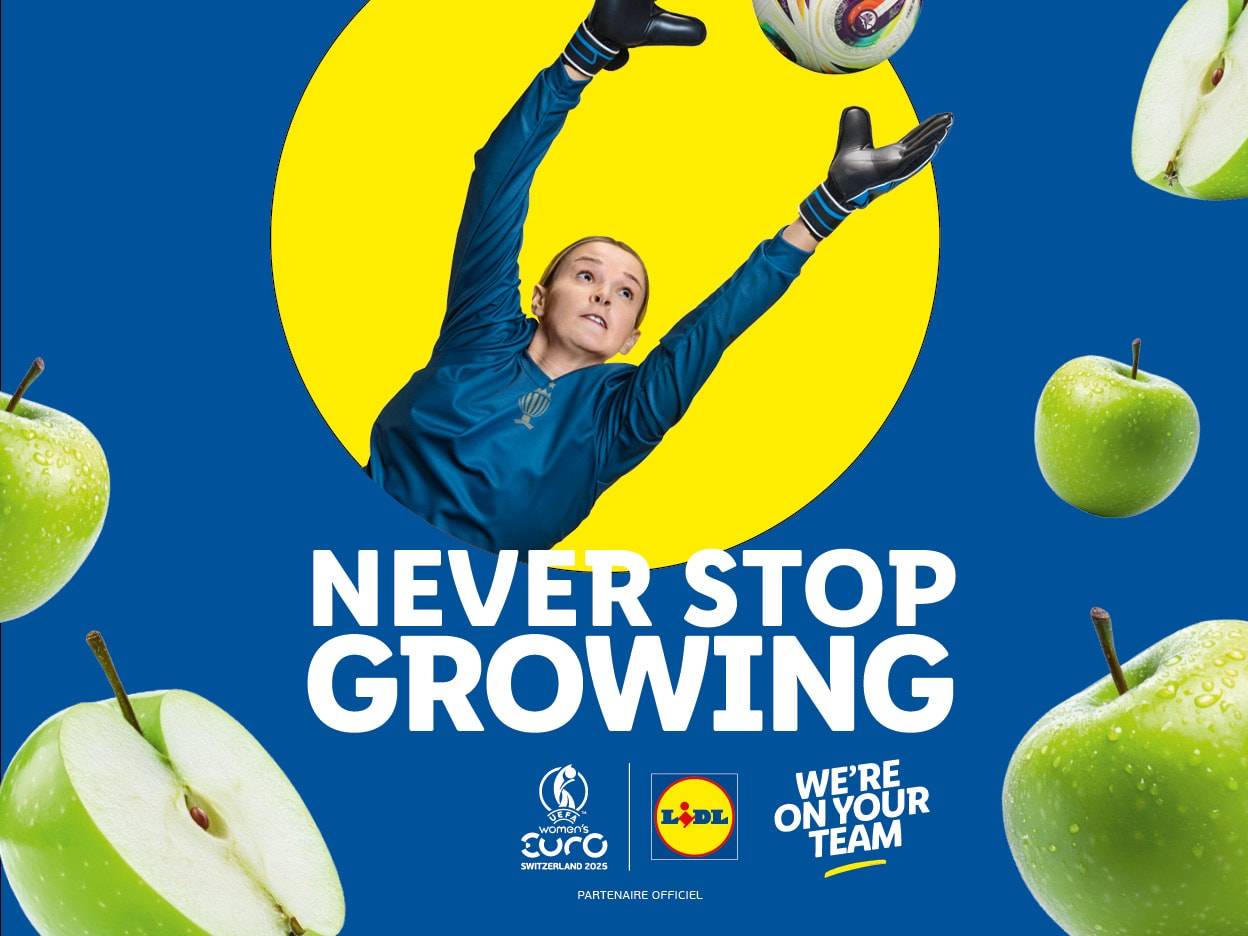 Publicité Lidl pour l'Euro féminin 2025 : une gardienne de but saute pour attraper un ballon, entourée de pommes.