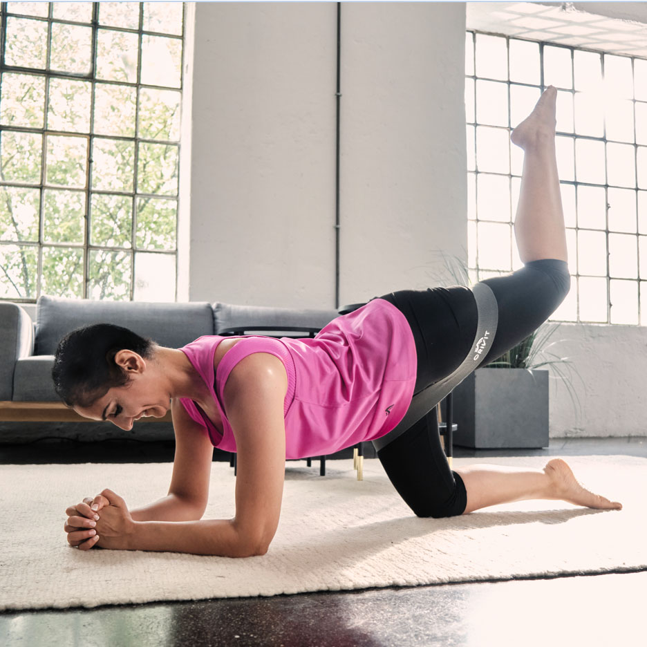 Femme faisant des exercices de jambes avec bande de résistance Senfit.