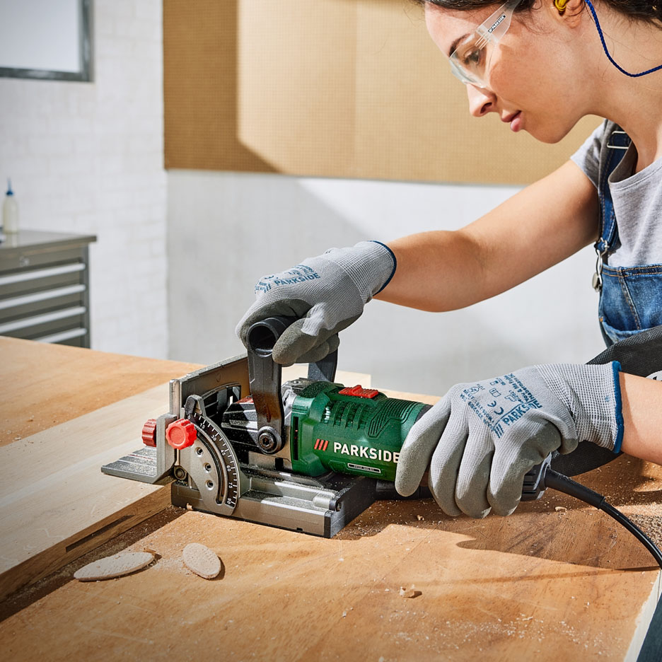Una donna usa uno strumento per la lavorazione del legno Parkside.