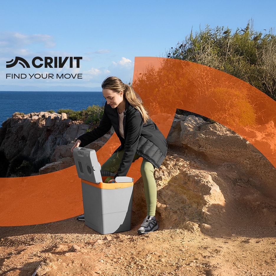 Frau öffnet eine Kühlbox auf einer Klippe mit Meer im Hintergrund.