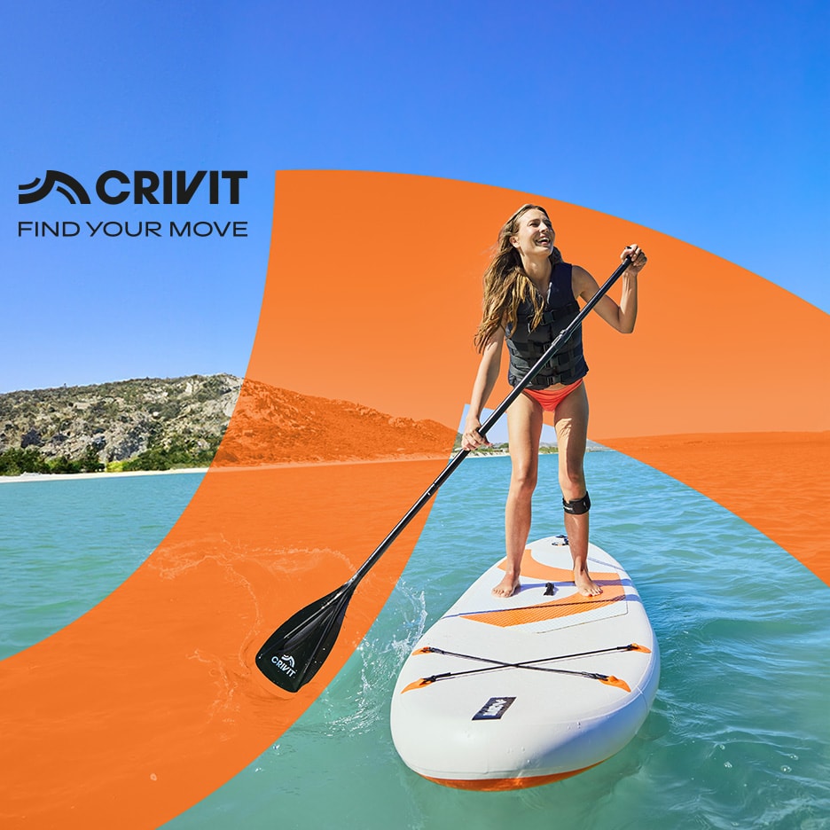 Frau auf einem Stand-Up-Paddle-Board mit Paddel auf dem Wasser, umgeben von Bergen.