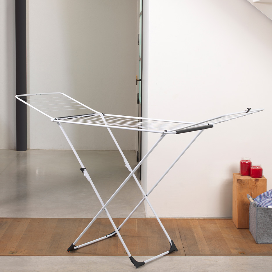 Weißer, klappbarer Wäscheständer in einem modernen Innenraum.