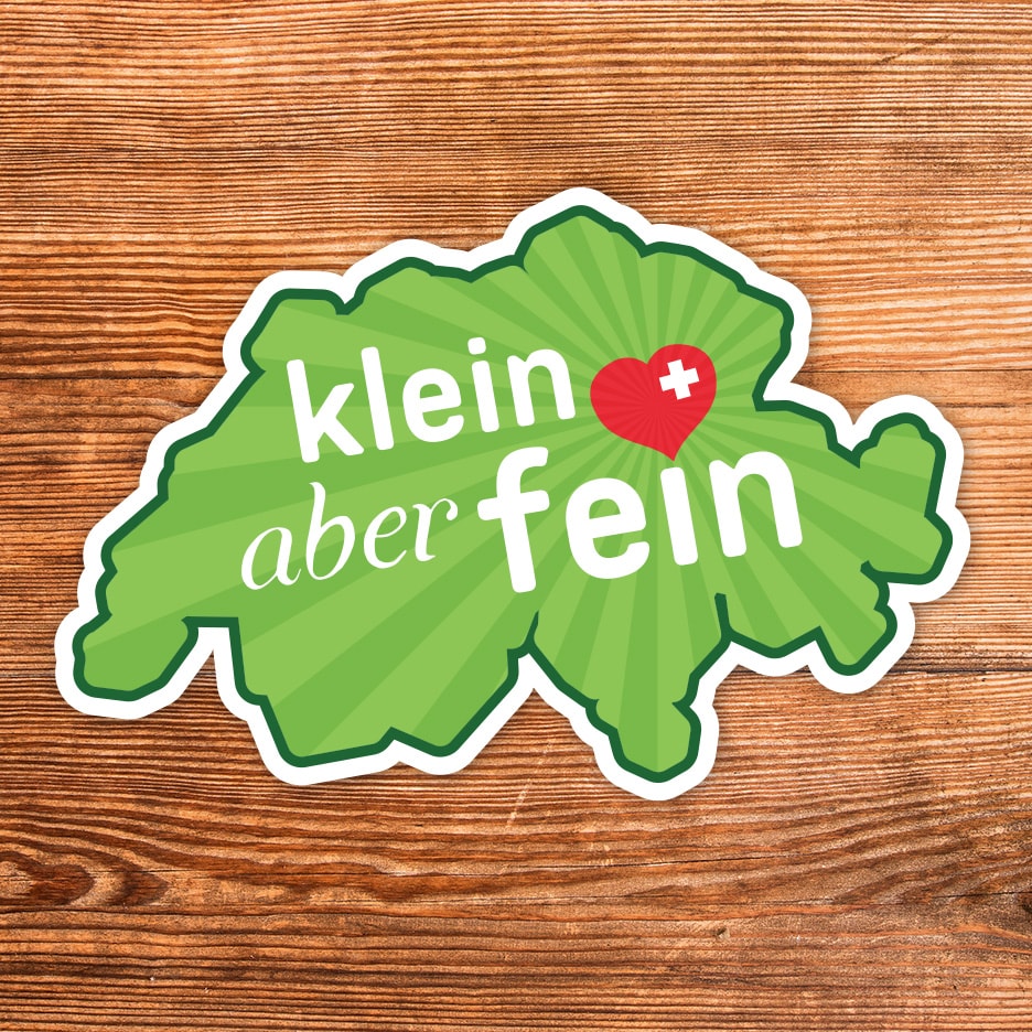 Aufkleber in Form einer Schweizer Karte mit der Aufschrift „klein aber fein“ und einem Herz.