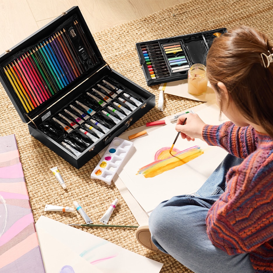 Malset mit Ölfarben, Buntstiften und Pastellkreiden, mit einer malenden Person.