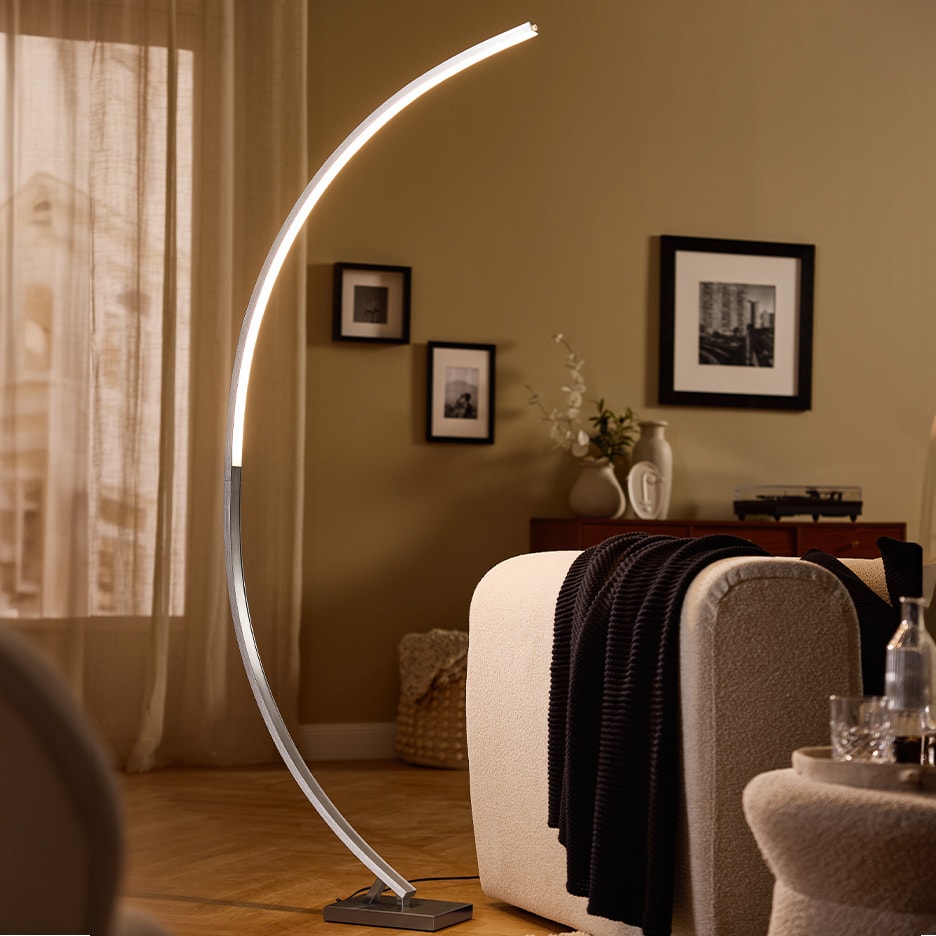 Moderne LED-Bogenlampe in einem Wohnzimmer mit Sofa und Dekoration.