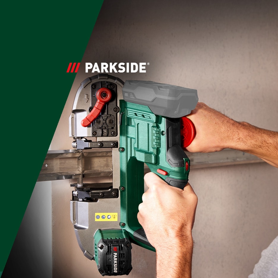 Eine Person hält eine grüne Akku-Bandsäge, die ein Metallprofil schneidet.