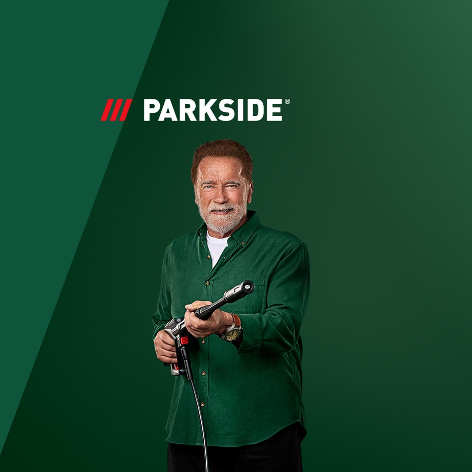 Arnold Schwarzenegger lächelnd mit einem Hochdruckreiniger vor grünem Hintergrund mit Logo.