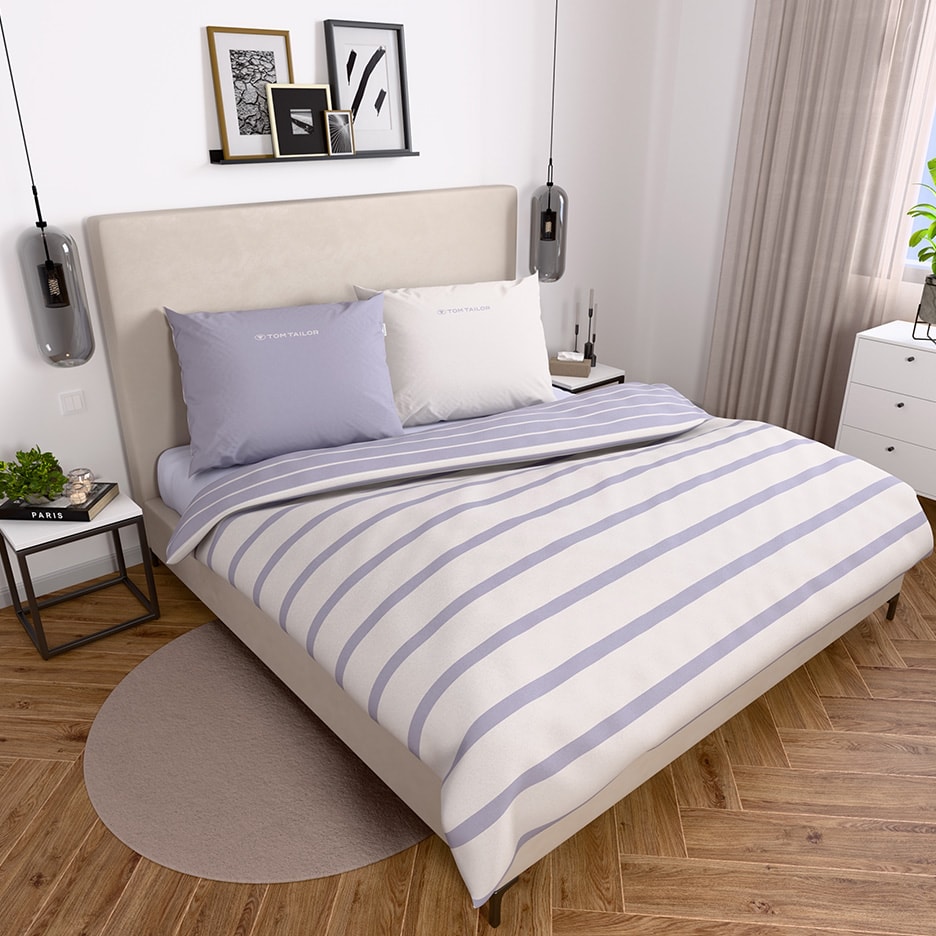 Schlafzimmer mit Tom Tailor Bettwäsche in Lila-Weiß gestreift und passenden Kissen.