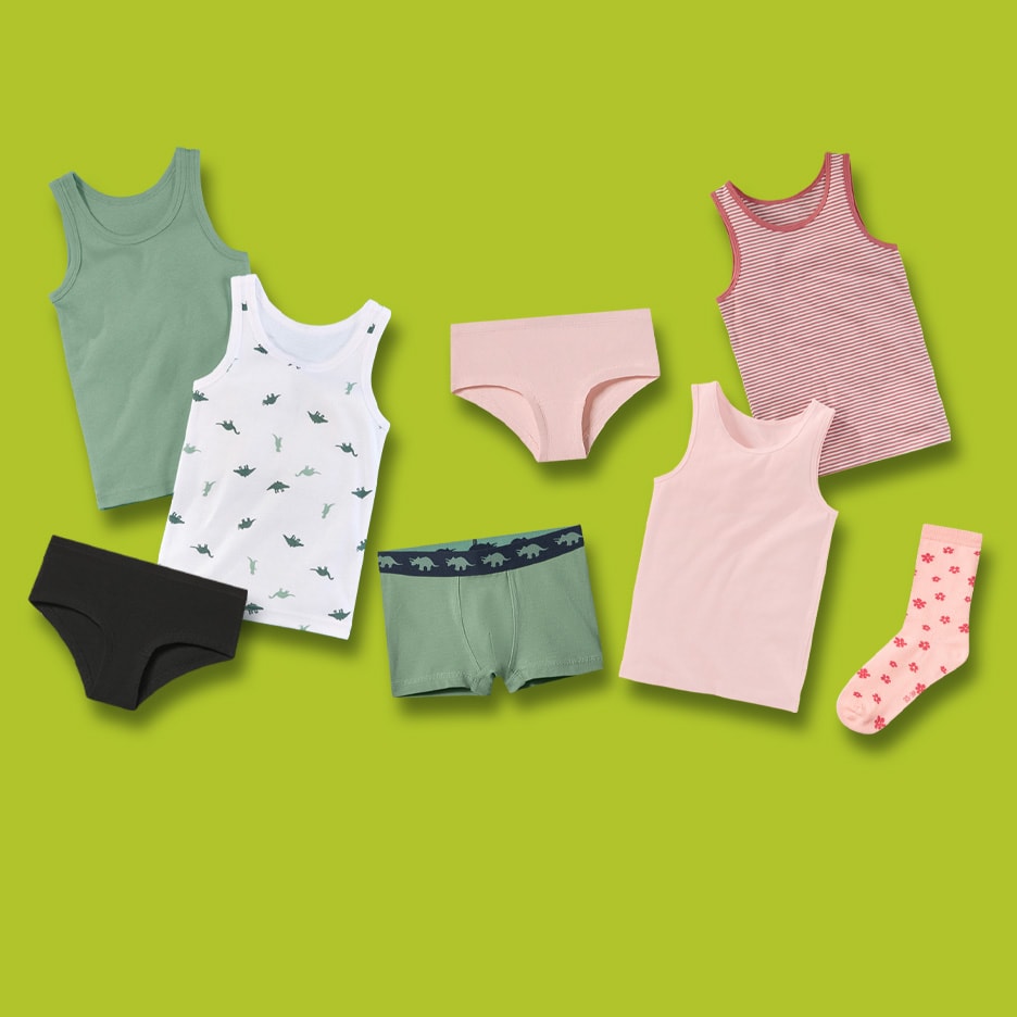 Sous-vêtements pour enfants : débardeurs et culottes de différentes couleurs et motifs, dont des dinosaures et des rayures.