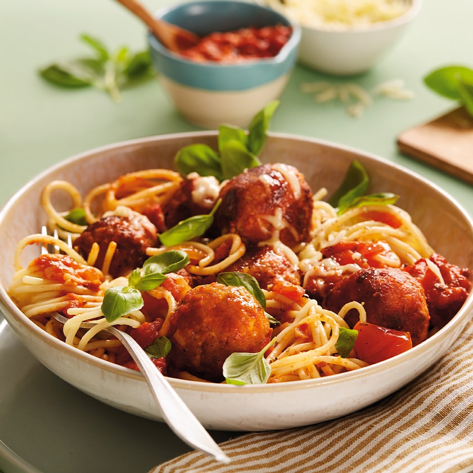 Spaghetti mit Fleischbällchen, Tomatensauce und Basilikum in einer Schale