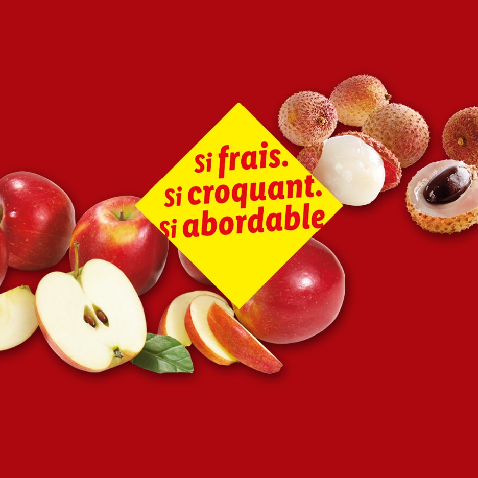 Frische, knackige und erschwingliche Äpfel und Litschis auf rotem Hintergrund.