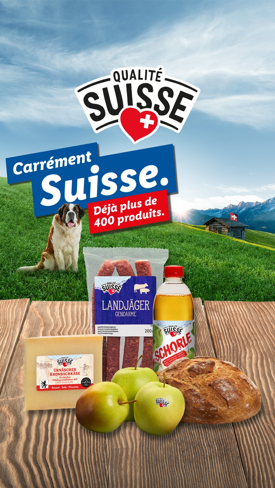 Schweizer Produkte wie Käse, Wurst, Äpfel und Brot auf einem Holztisch, mit einem Bernhardiner und Alpenlandschaft im Hintergrund.