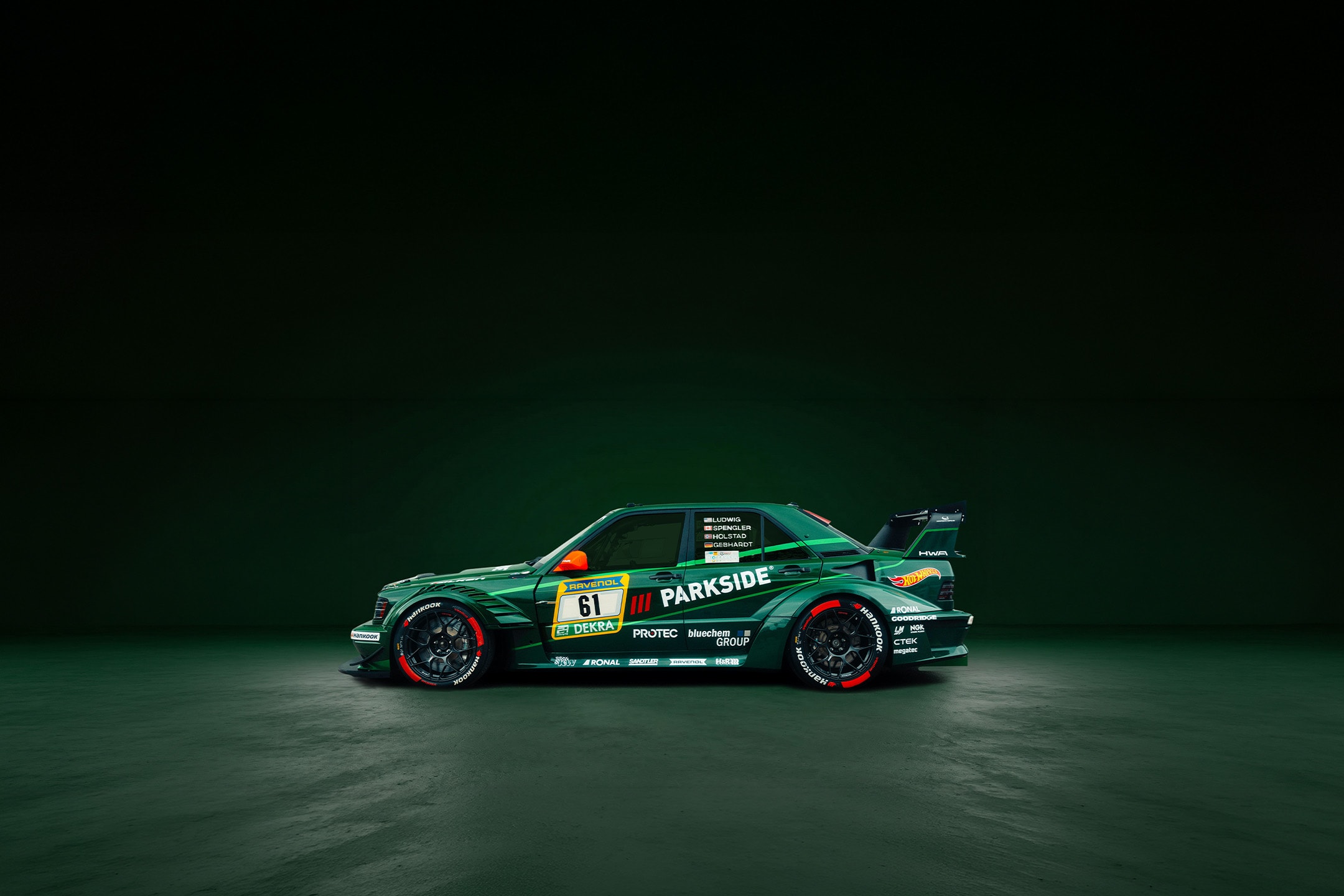 Voiture de course numéro 61 avec logos de sponsors sur fond vert.