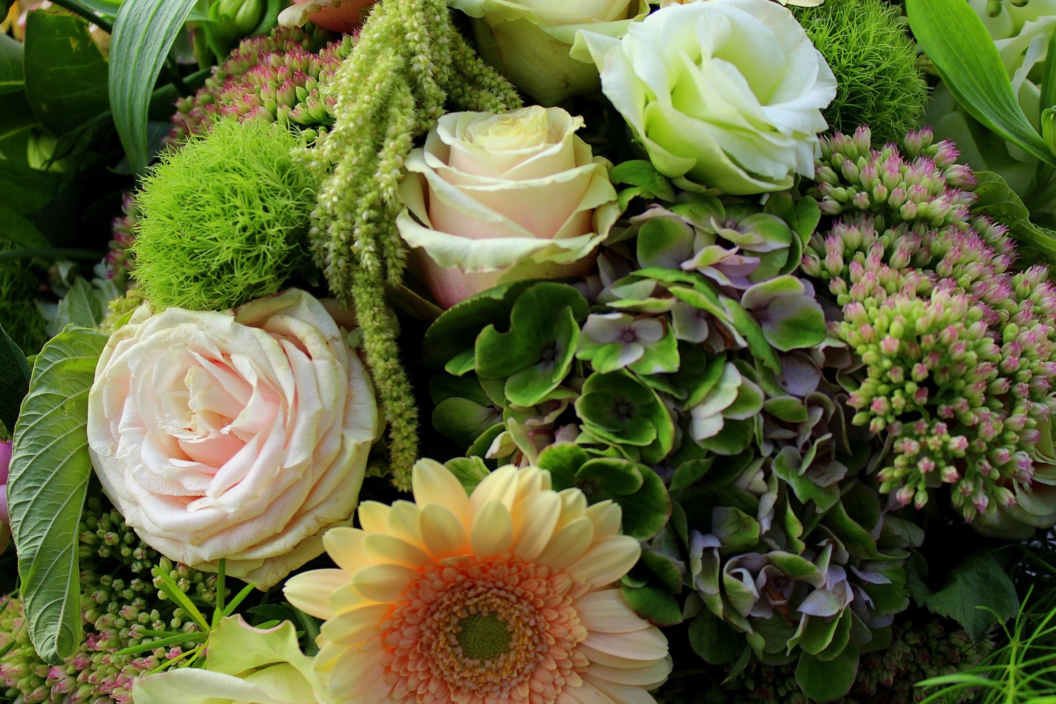 Ein farbenfroher Blumenstrauß mit Rosen, Hortensien und Gerbera.