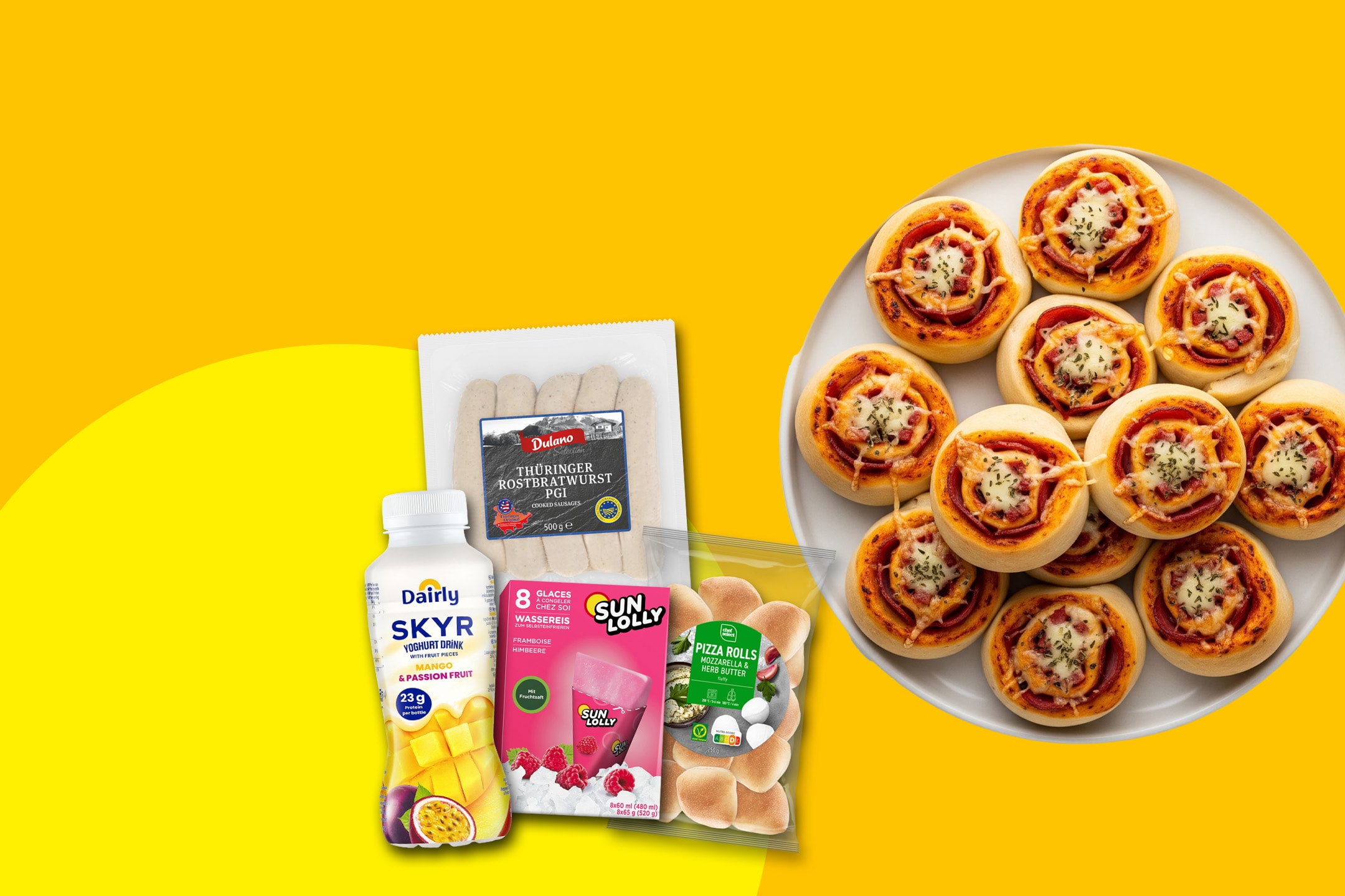 Eine Auswahl an Lebensmitteln, darunter Mini-Pizzabrötchen, Joghurtgetränk, Würstchen und Wassereis.