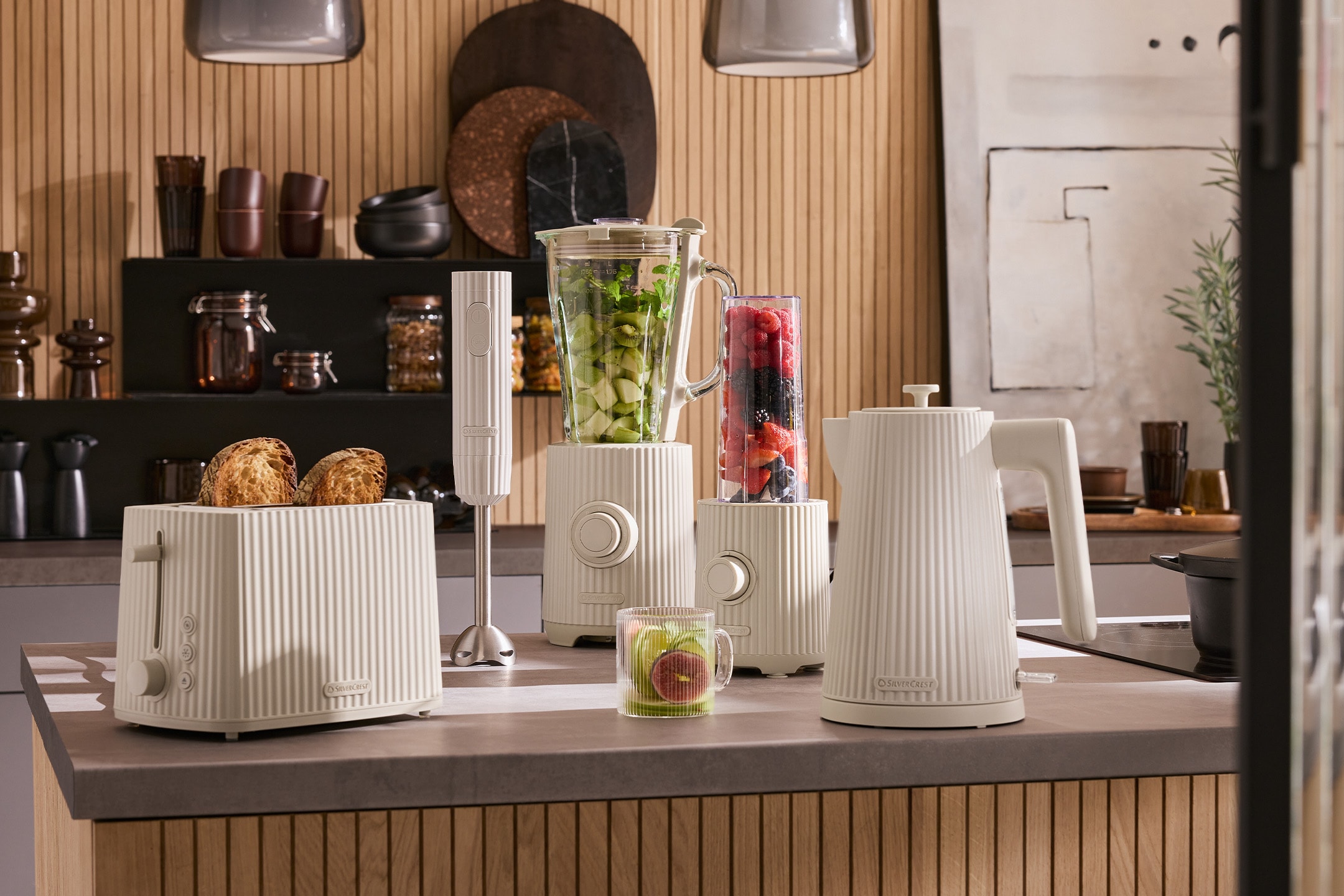 Grille-pain, mixeur et bouilloire crème sur un comptoir de cuisine en bois.