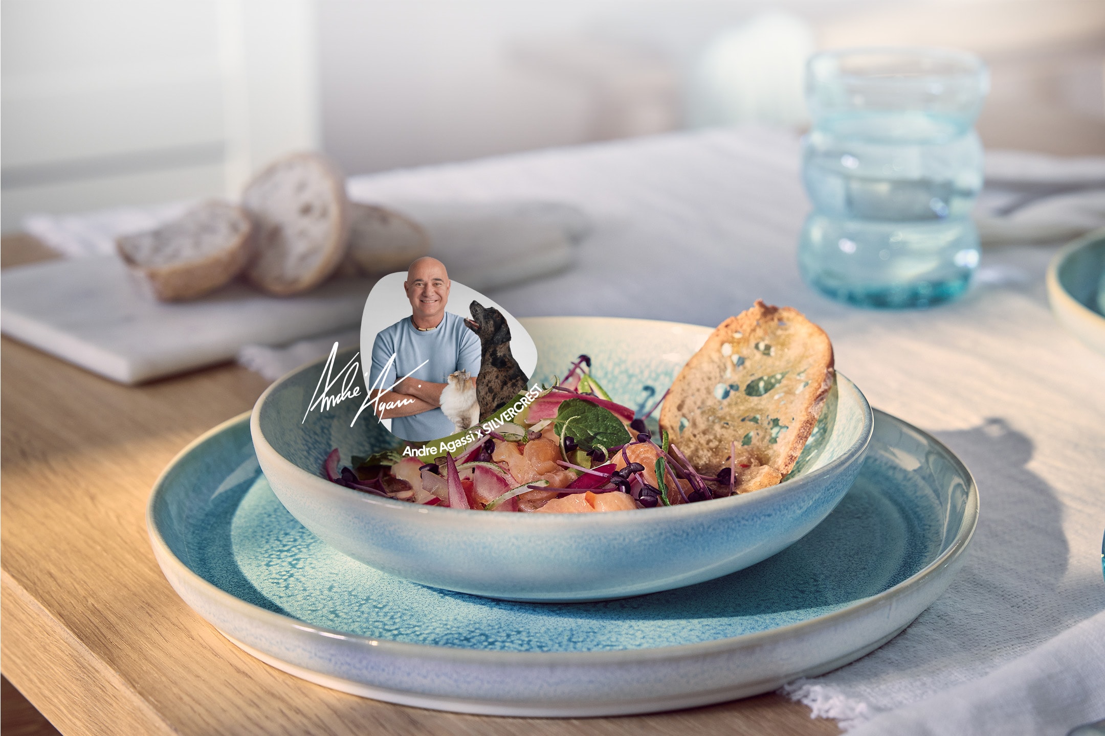 Una ciotola di ceviche di salmone e pane su un tavolo di legno, con un'immagine di Andre Agassi.