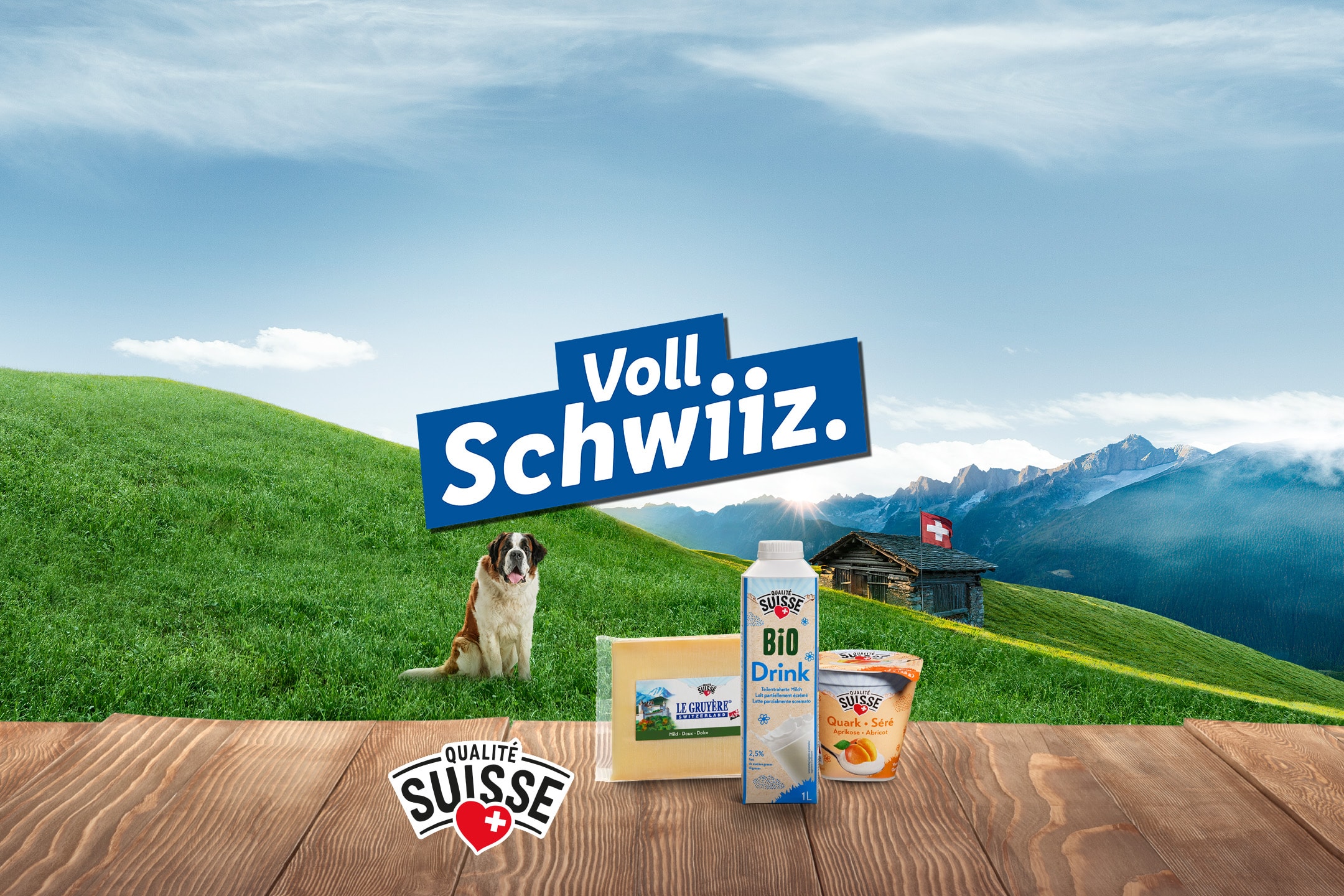 Schweizer Milchprodukte wie Käse, Milchgetränk und Quark vor Alpenkulisse mit Bernhardiner.