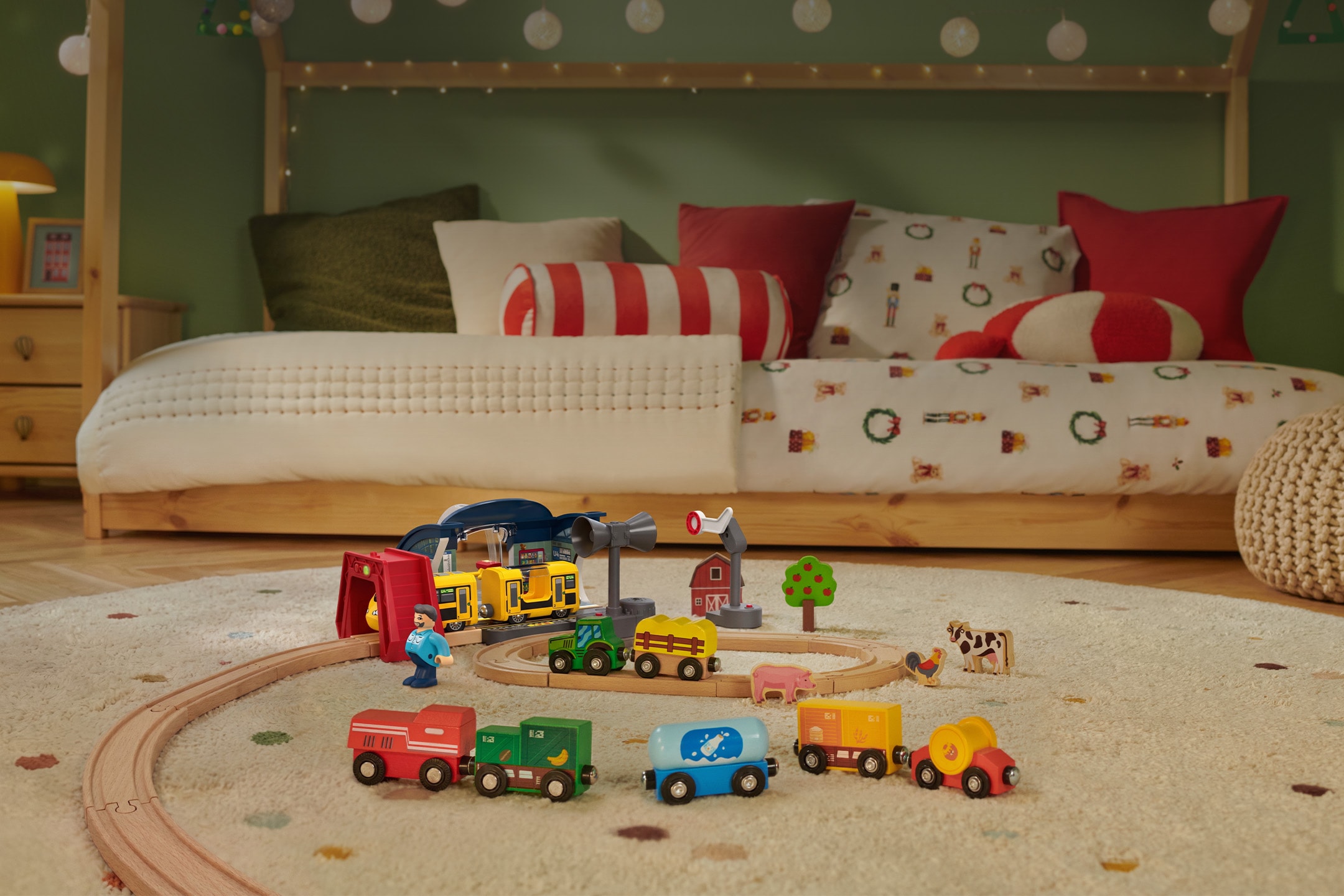 Holzeisenbahn-Set für Kinder, aufgebaut auf einem Teppich im Kinderzimmer.