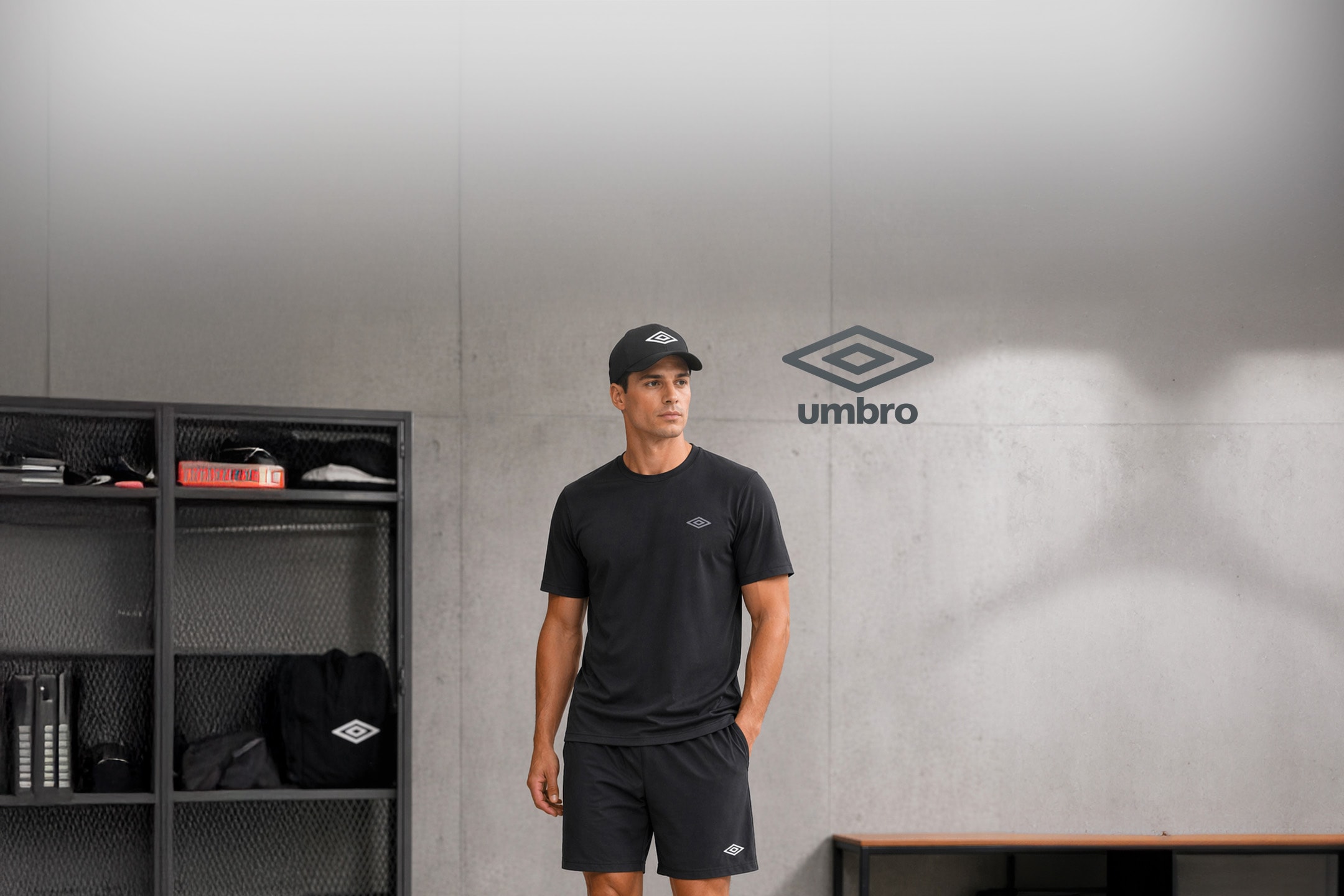 Homme en tenue de sport noire avec casquette, dans un vestiaire.