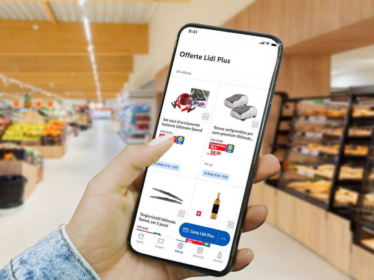 Mano che tiene uno smartphone con l'app Lidl Plus, mostrando offerte di accessori auto e tergicristalli.