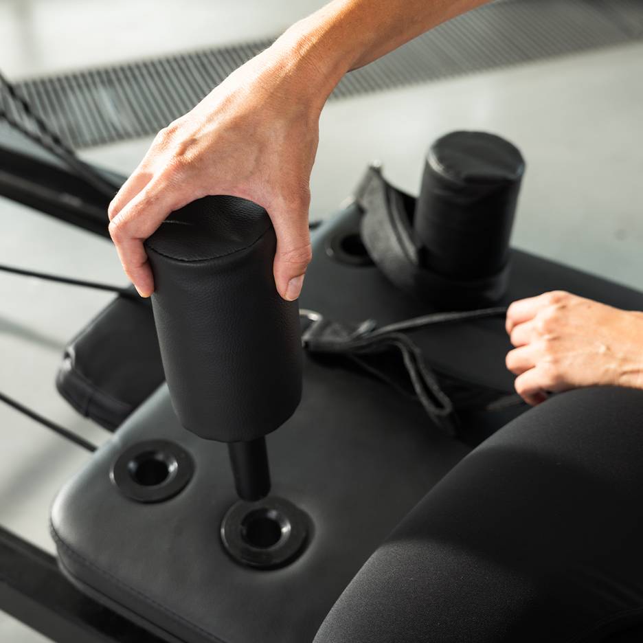 Persona che regola una macchina per esercizi imbottita nera.
