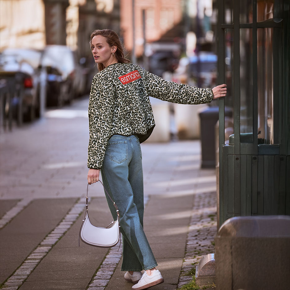 Femme en veste léopard Esmara et jean, avec un sac à main, dans la rue.