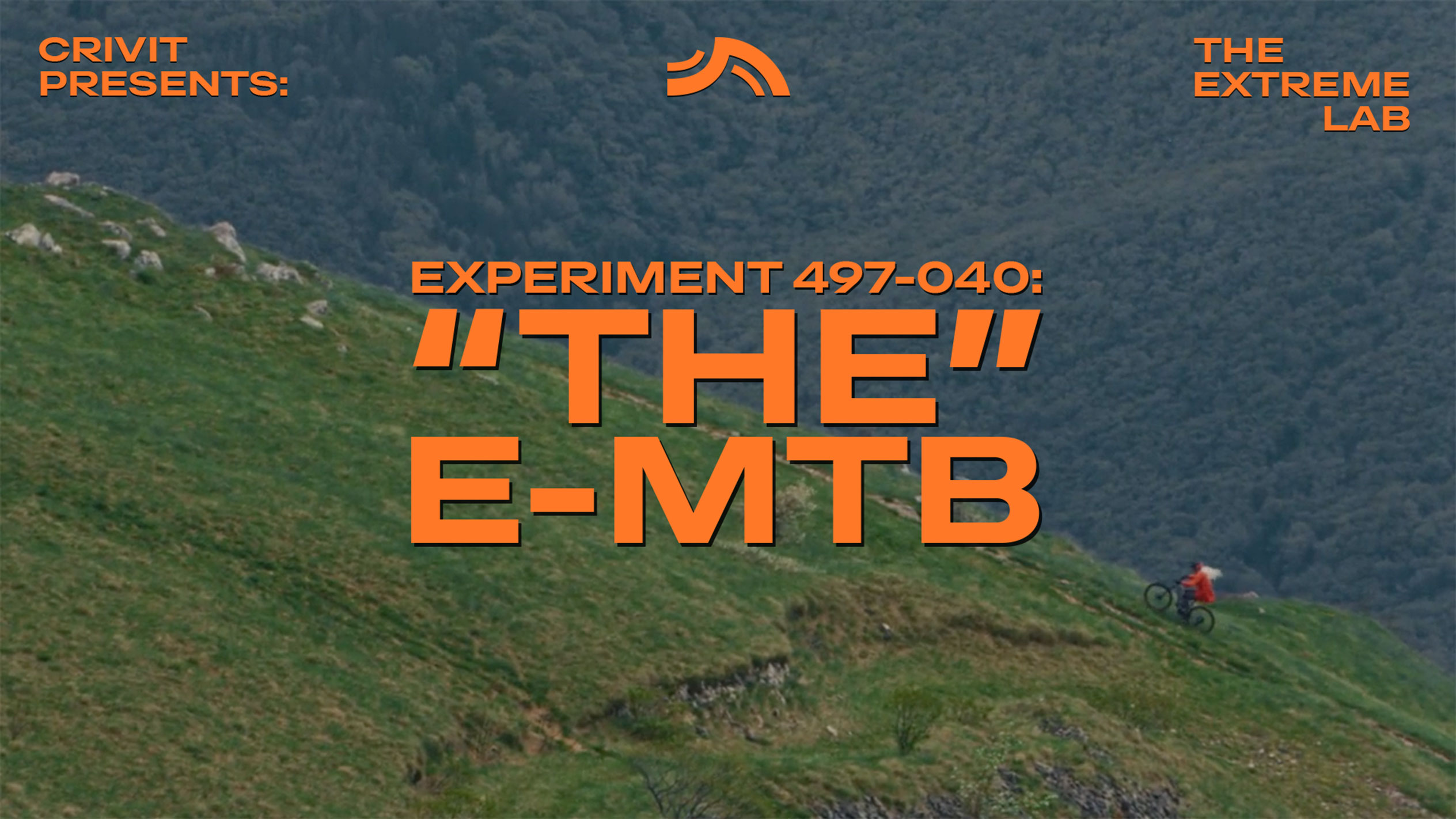 Mountainbiker auf einem grasbewachsenen Hang, mit Text 'THE E-MTB' und 'THE EXTREME LAB'.