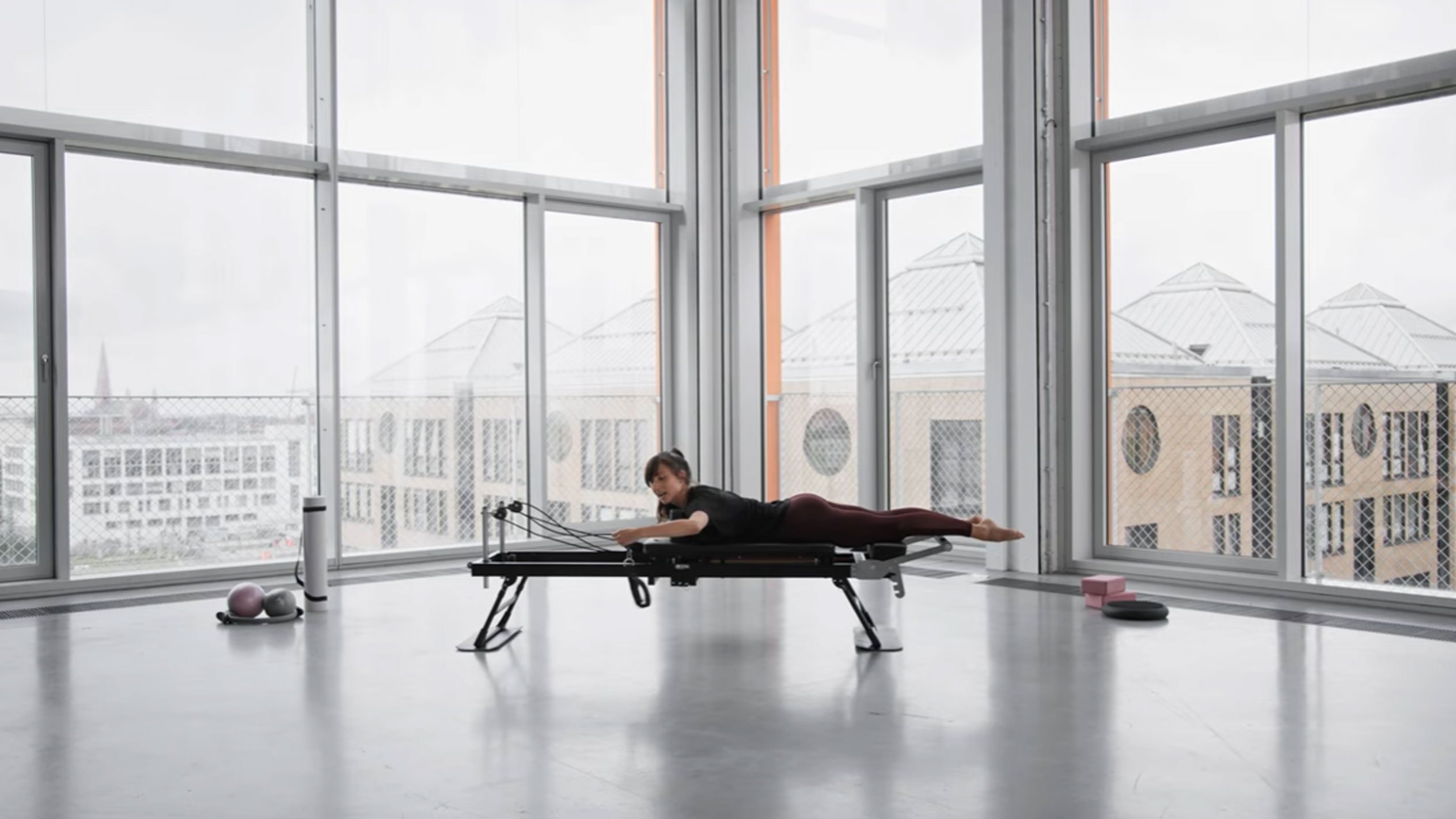 Donna che fa Pilates su un reformer, con vista sulla città.
