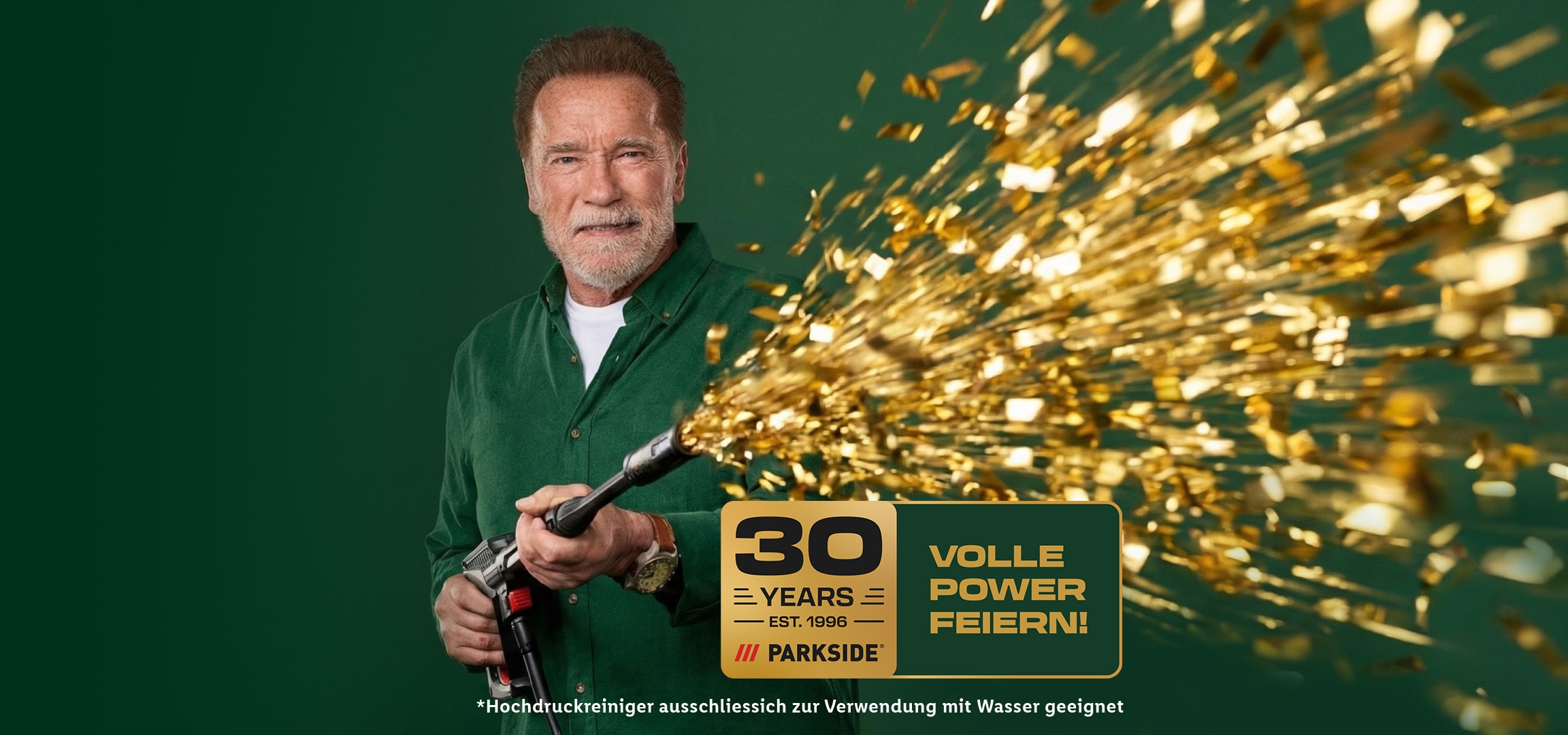 Lächelnder Mann mit Hochdruckreiniger, der goldene Konfetti verschießt, feiert 30 Jahre Power.