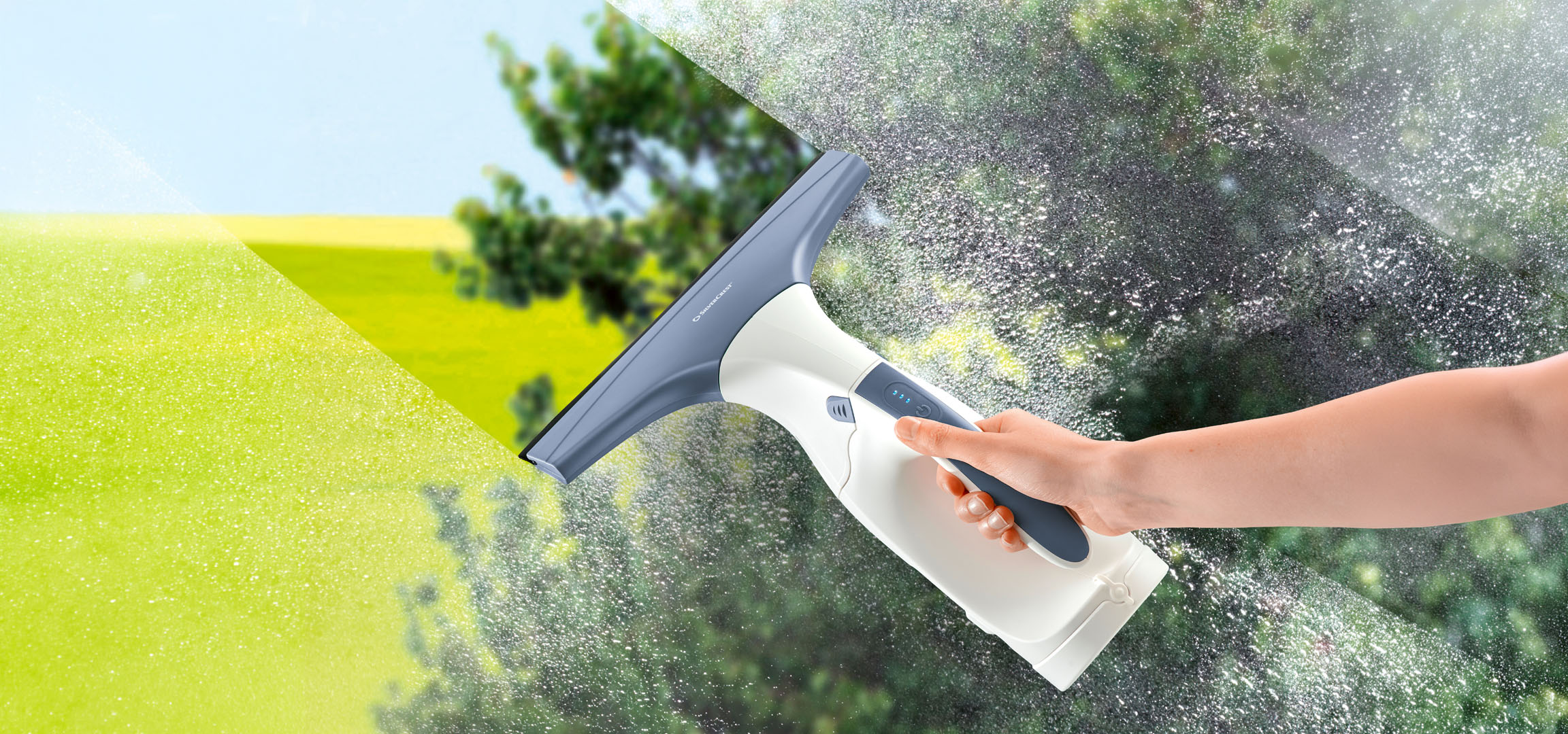 Main nettoyant une vitre sale avec un lave-vitre électrique.