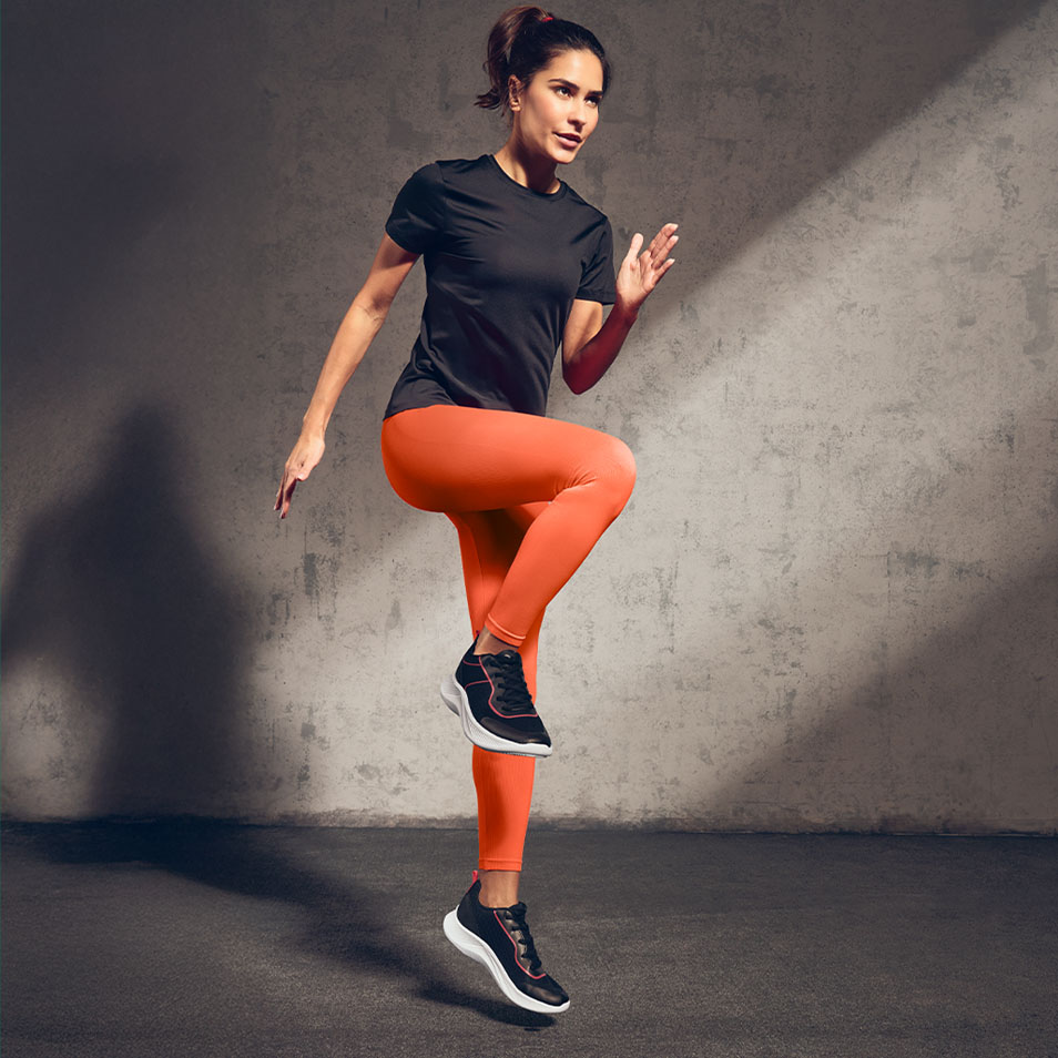 Frau in schwarzem Sport-T-Shirt und orangefarbenen Leggings beim Training