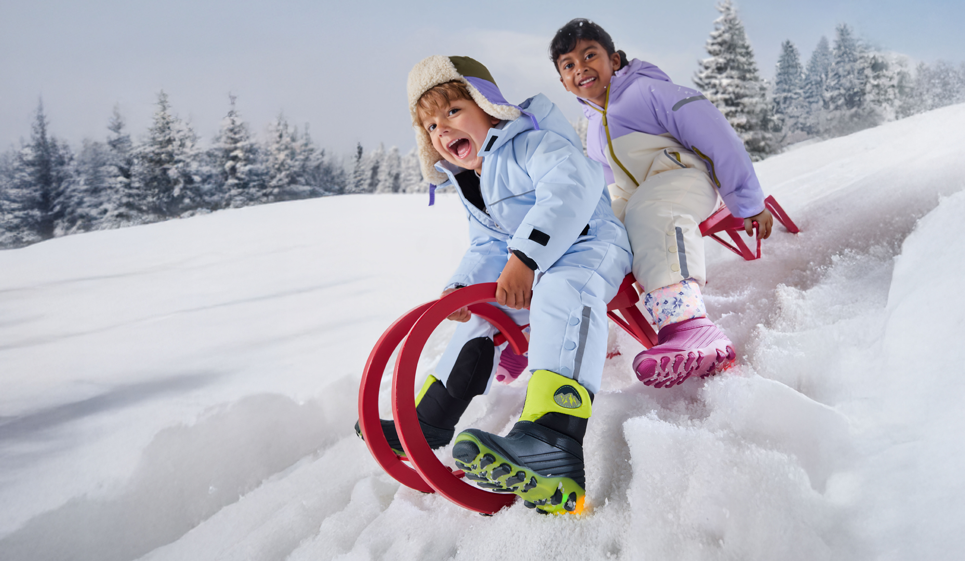 Deux enfants en combinaisons de neige et bottes d'hiver, faisant de la luge sur la neige.