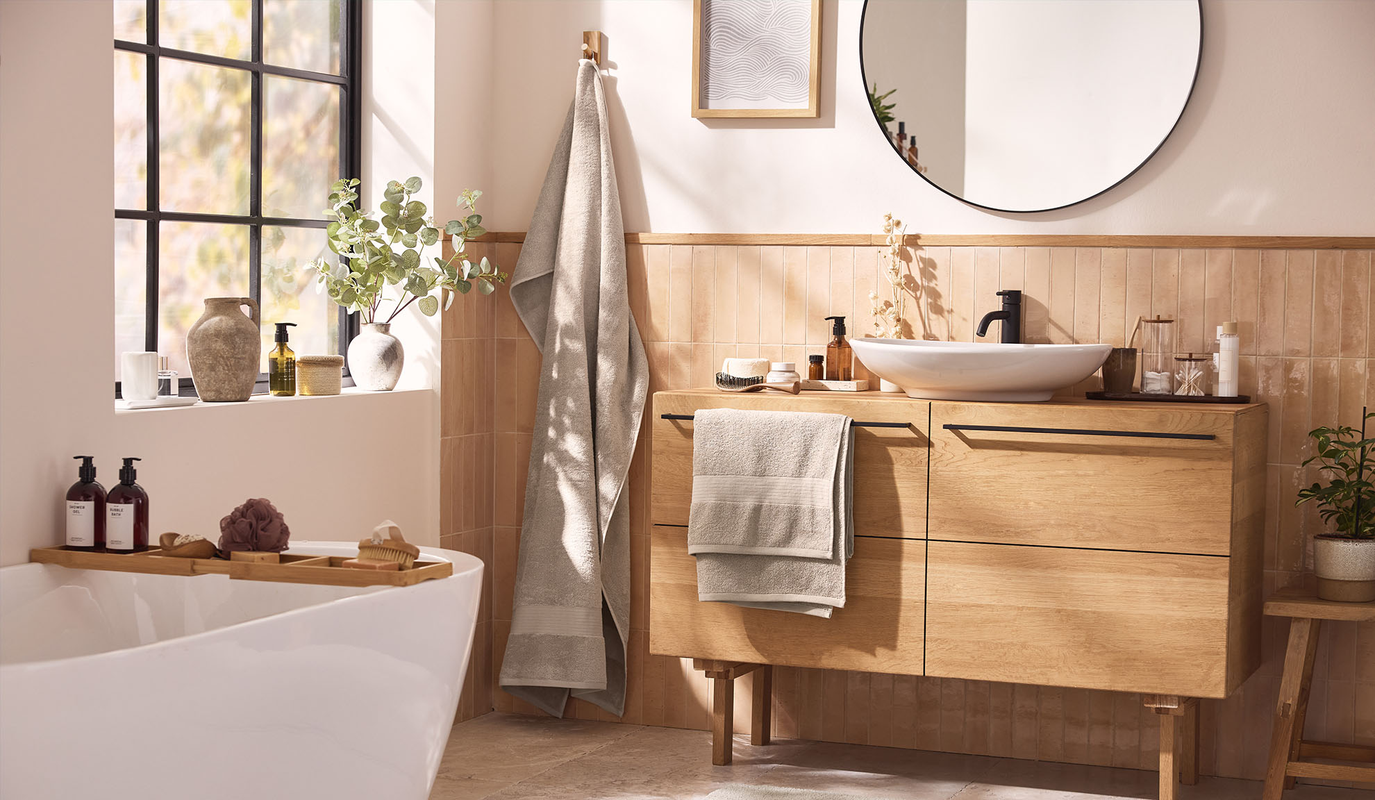 Modernes Badezimmer mit Holzbadmöbeln, einer Badewanne und einem Fenster.