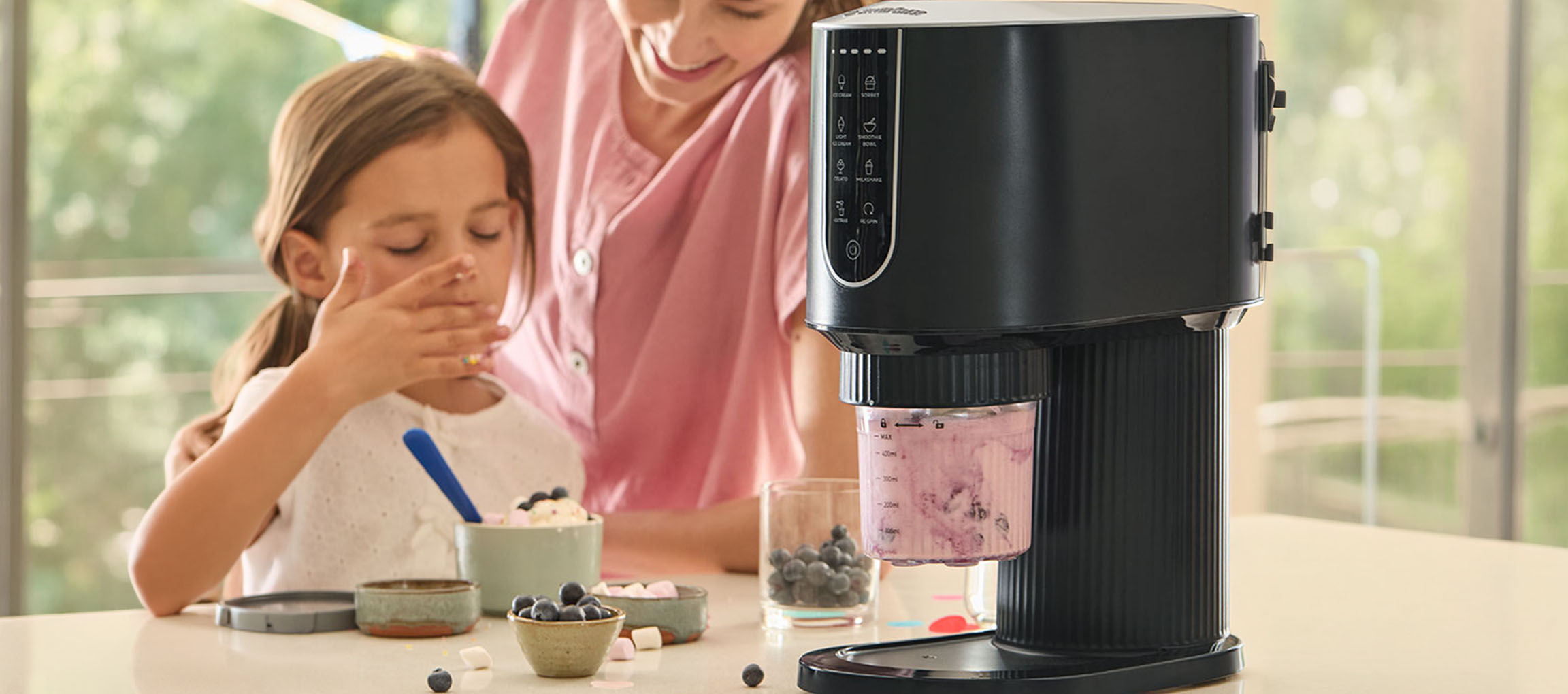 Machine à glace préparant de la glace aux baies, enfant et adulte savourant le dessert.