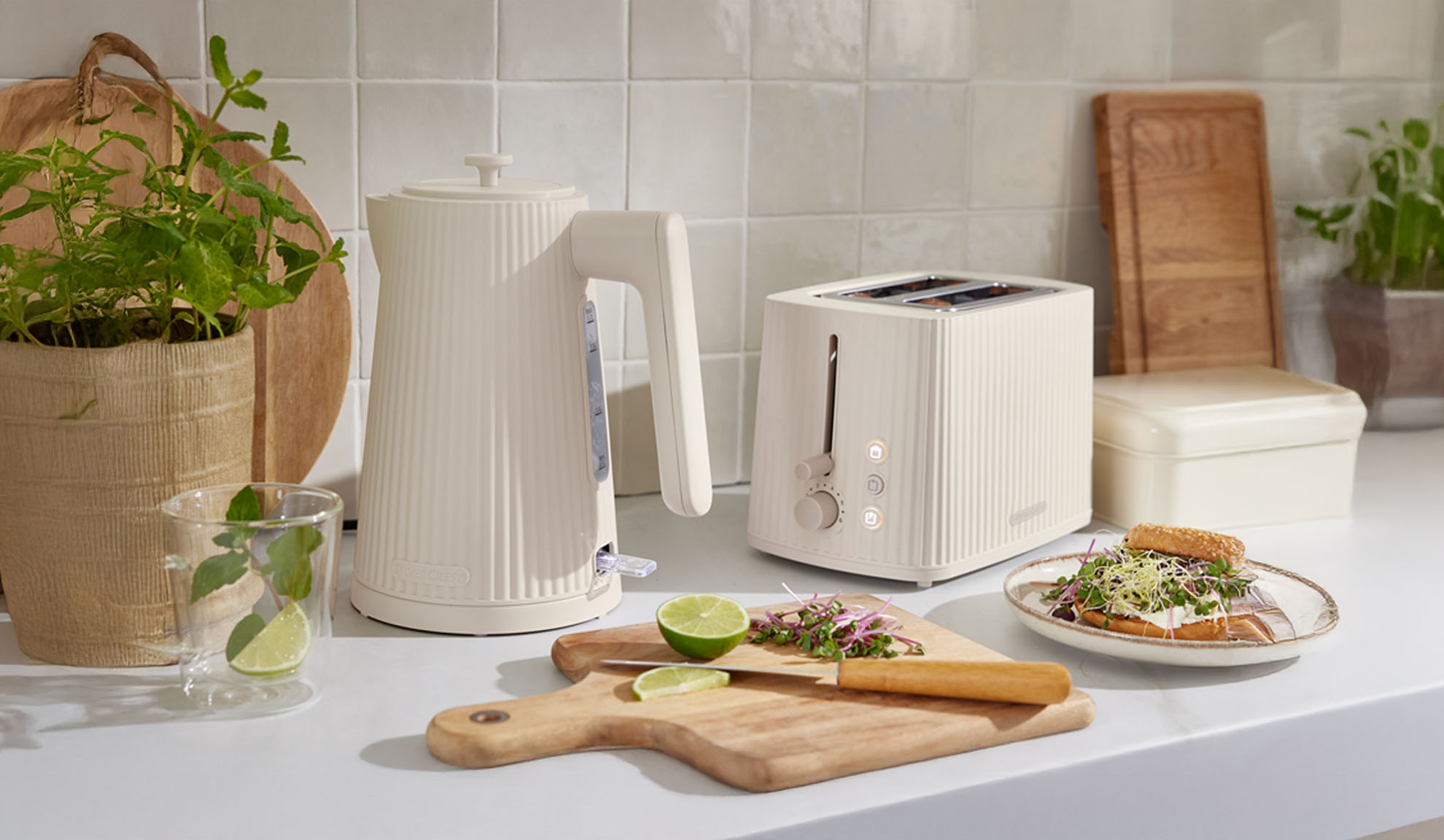 Cremefarbener gerippter Wasserkocher und Toaster auf einer Küchenarbeitsplatte.
