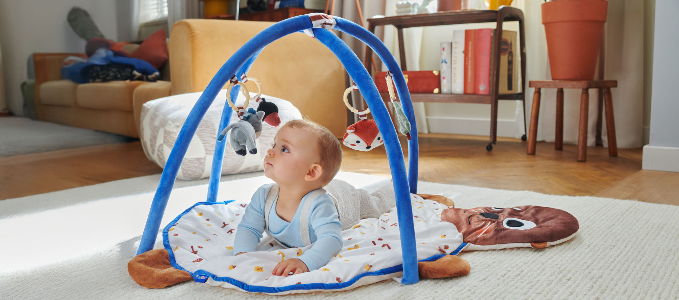 Ein Baby spielt auf einer Little Dutch Spielmatte in Form einer Robbe.