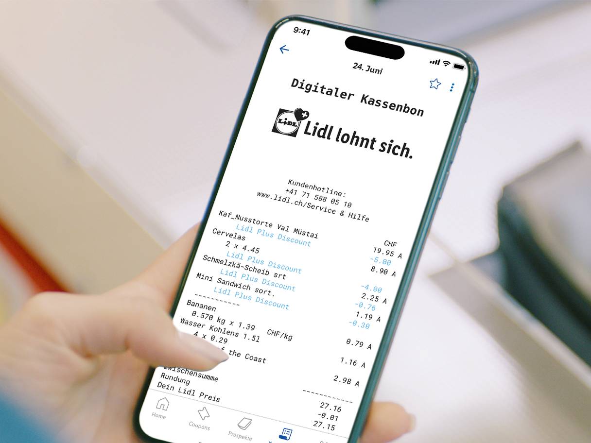 Eine Hand hält ein Smartphone mit einer digitalen Quittung, die eine Nusstarte, Cervelas und Bananen auflistet.