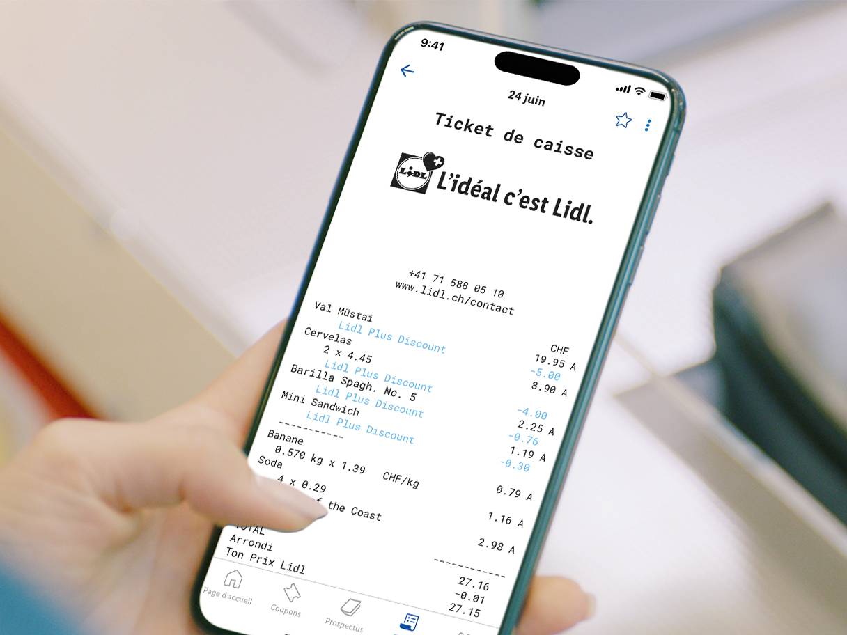 Une personne tient un smartphone affichant un ticket de caisse numérique avec des articles comme des cervelas, des pâtes, des sandwichs, des bananes et des sodas.