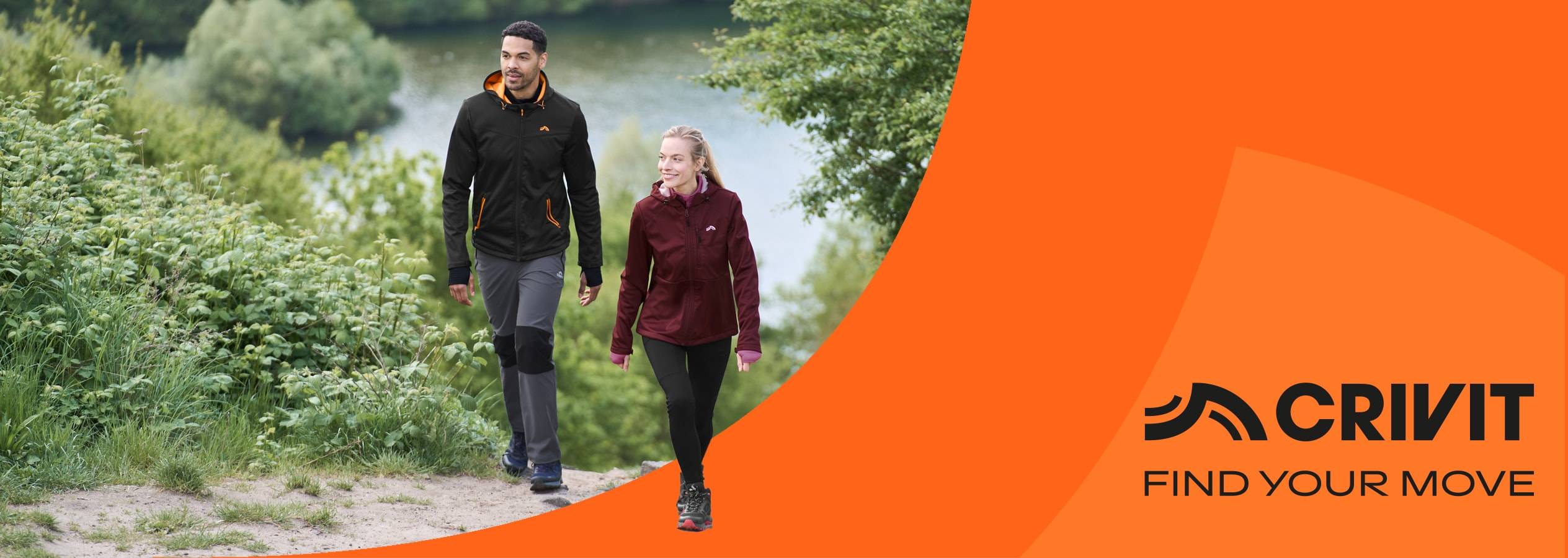 Due escursionisti in abbigliamento outdoor camminano su un sentiero vicino a un lago, con un logo Crivit.