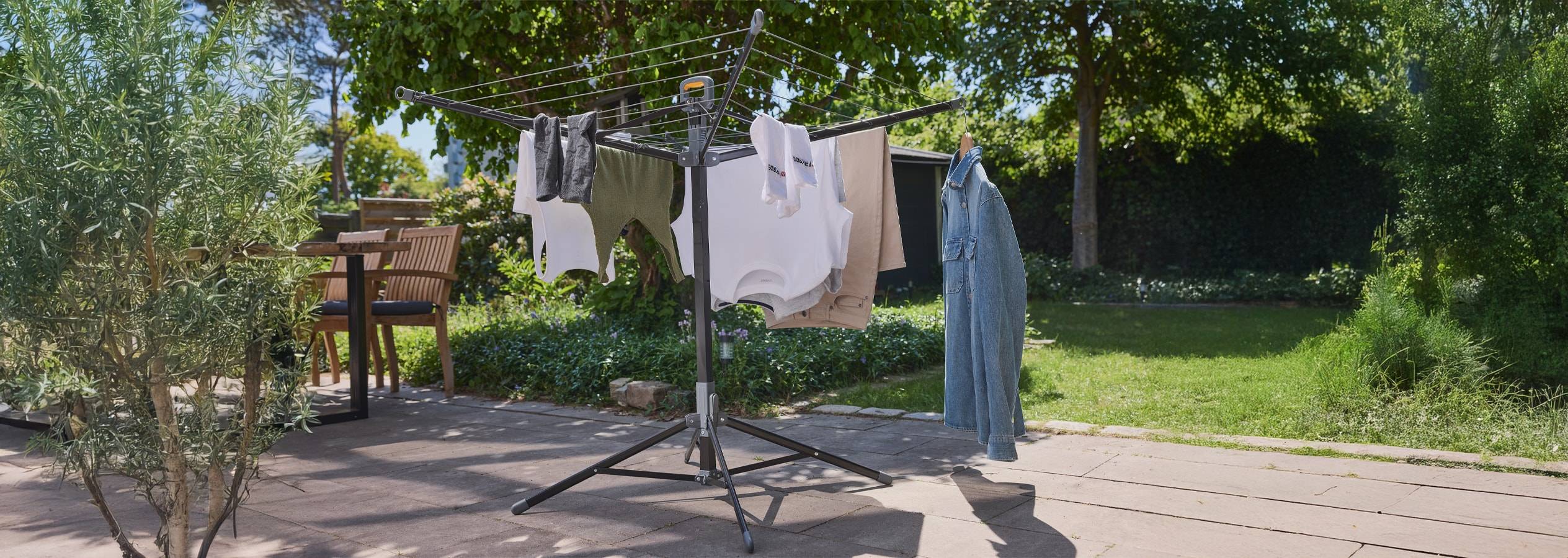 Stendibiancheria con vestiti appesi in un patio esterno.